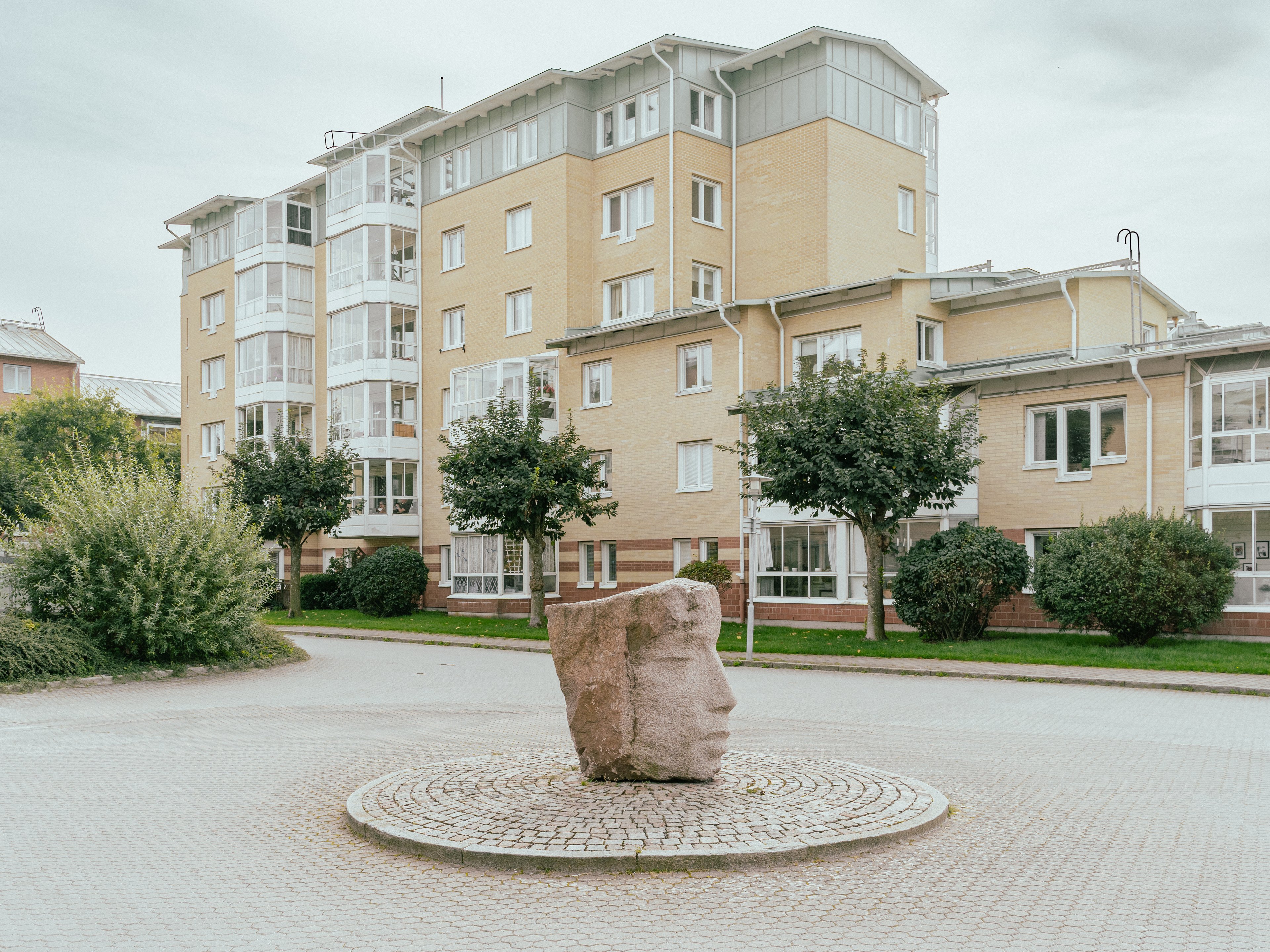Ett ansikte uthugget ur granit står i en rondell