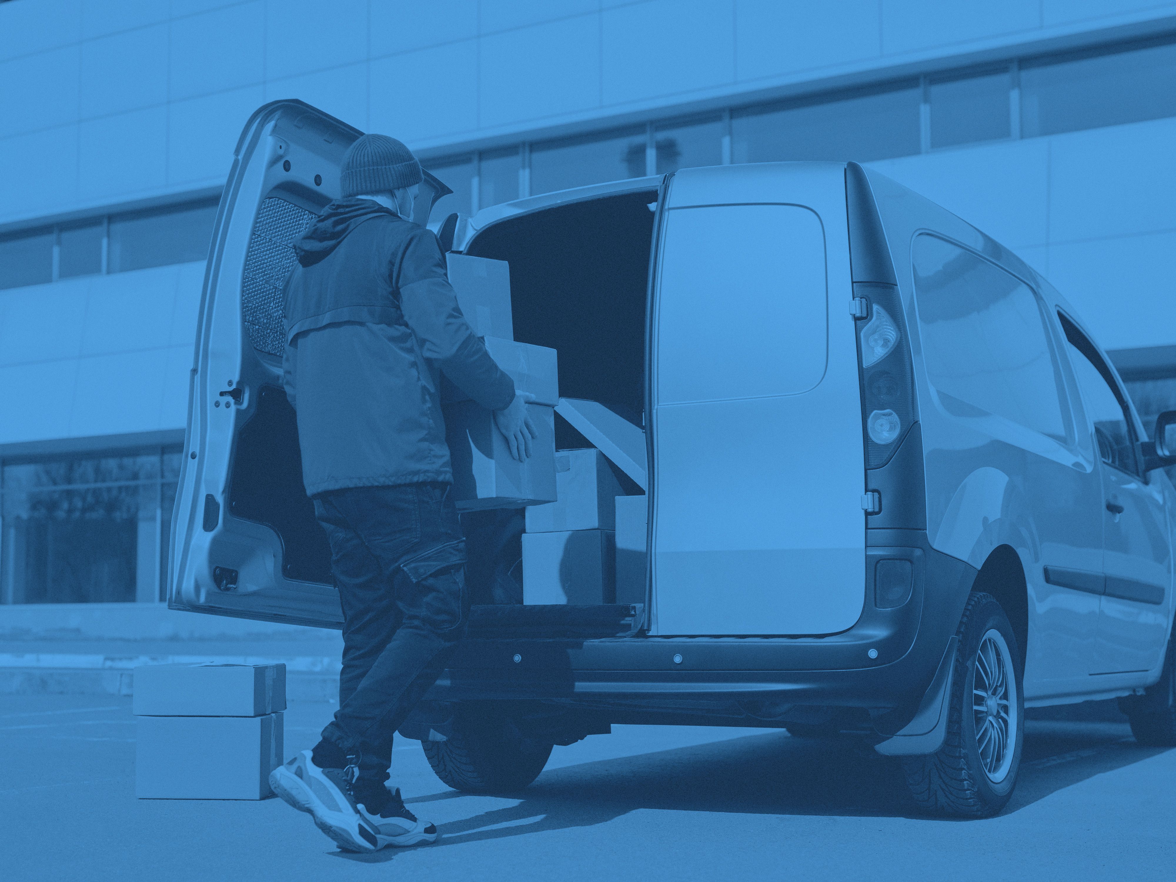 En person bär in flyttkartonger i en bil