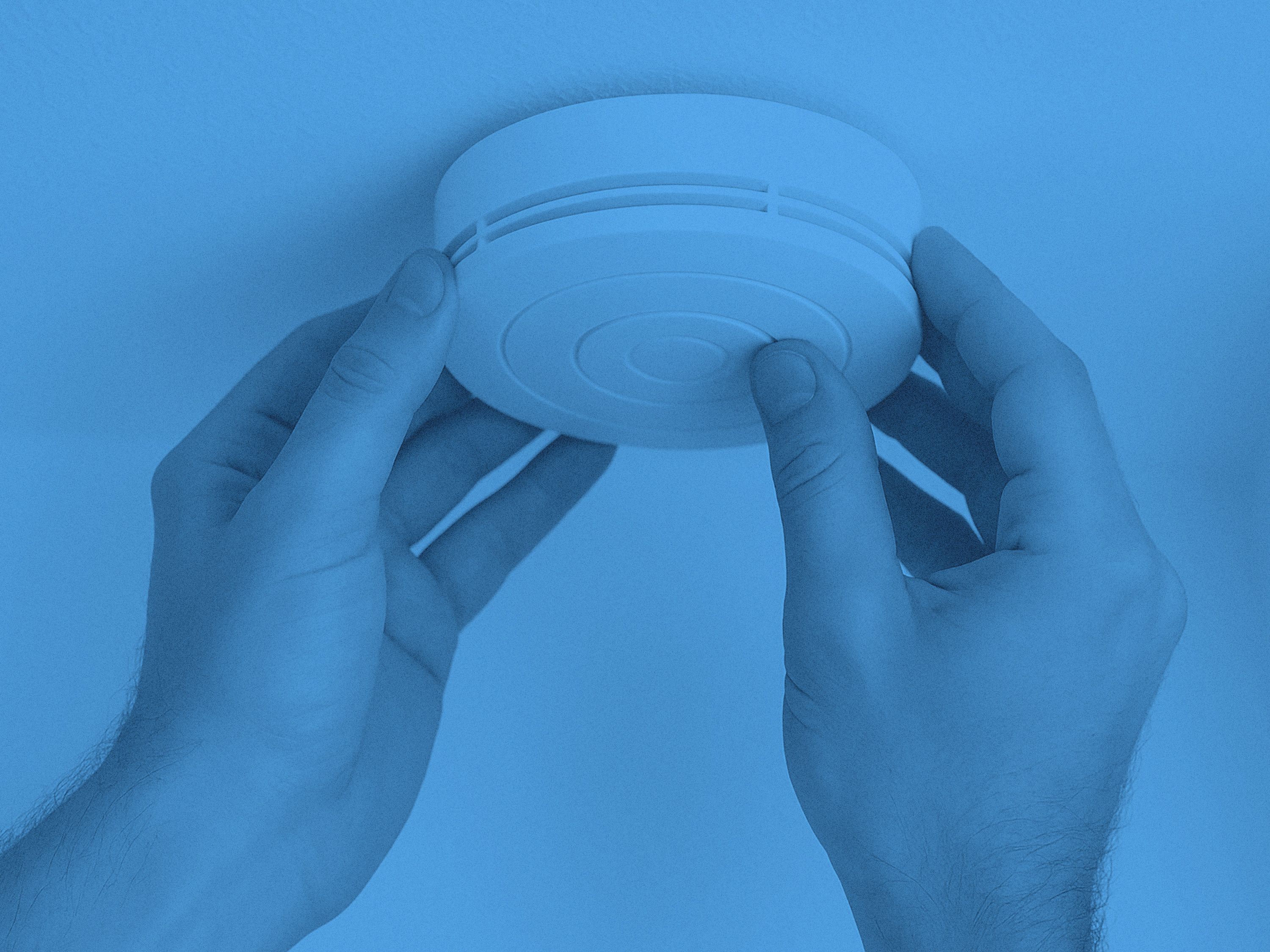 En brandvarnare och två händer