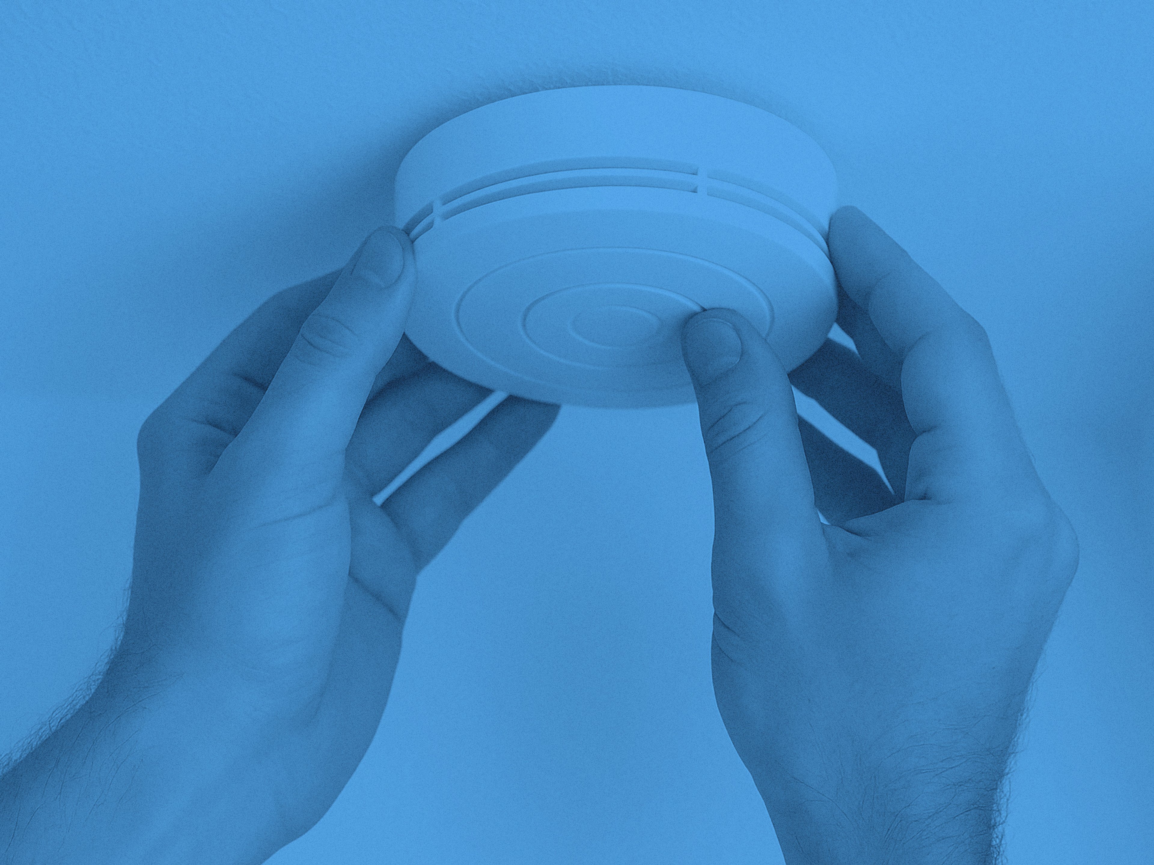 En brandvarnare och två händer