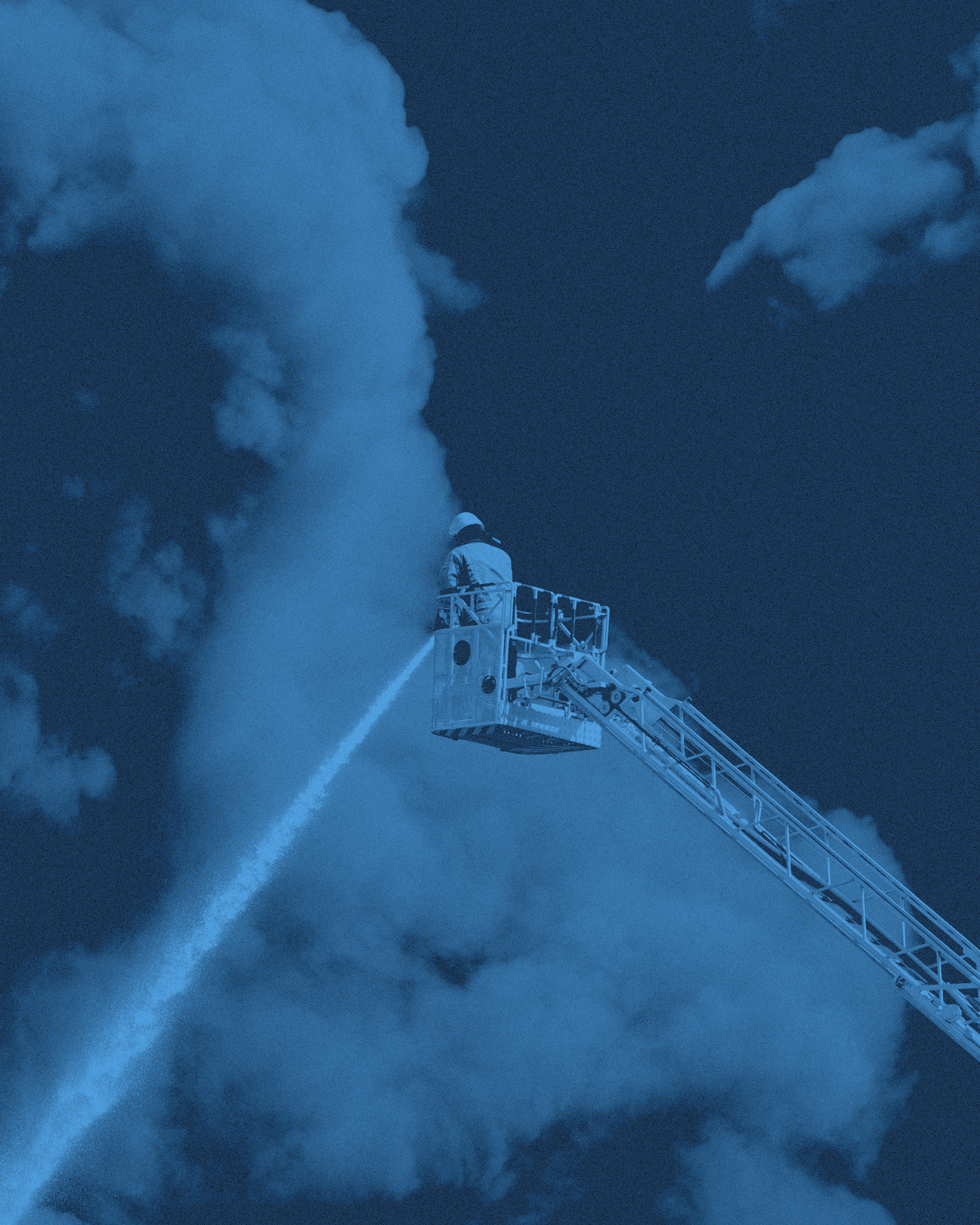 En brandman på stege som sprutar vatten