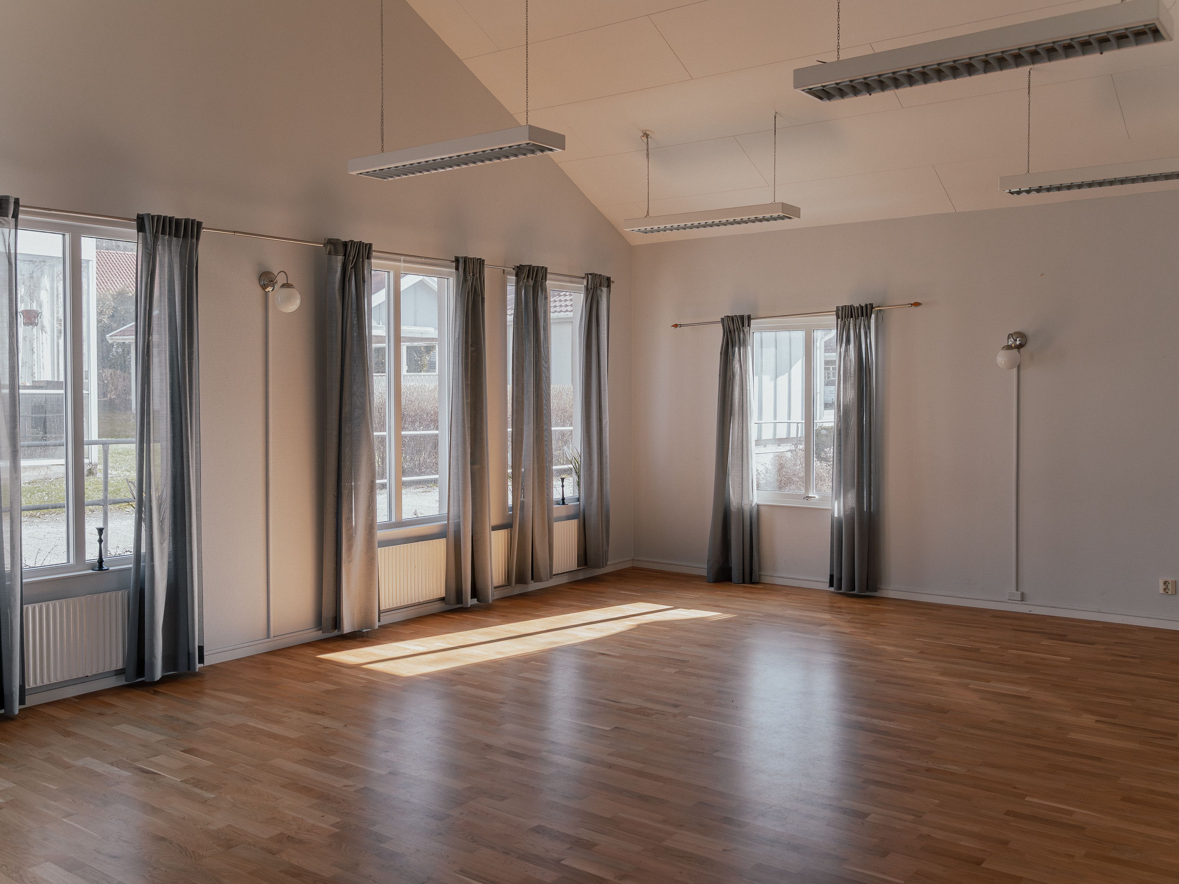 Ett stort tomt rum med stora fönster och mycket ljus