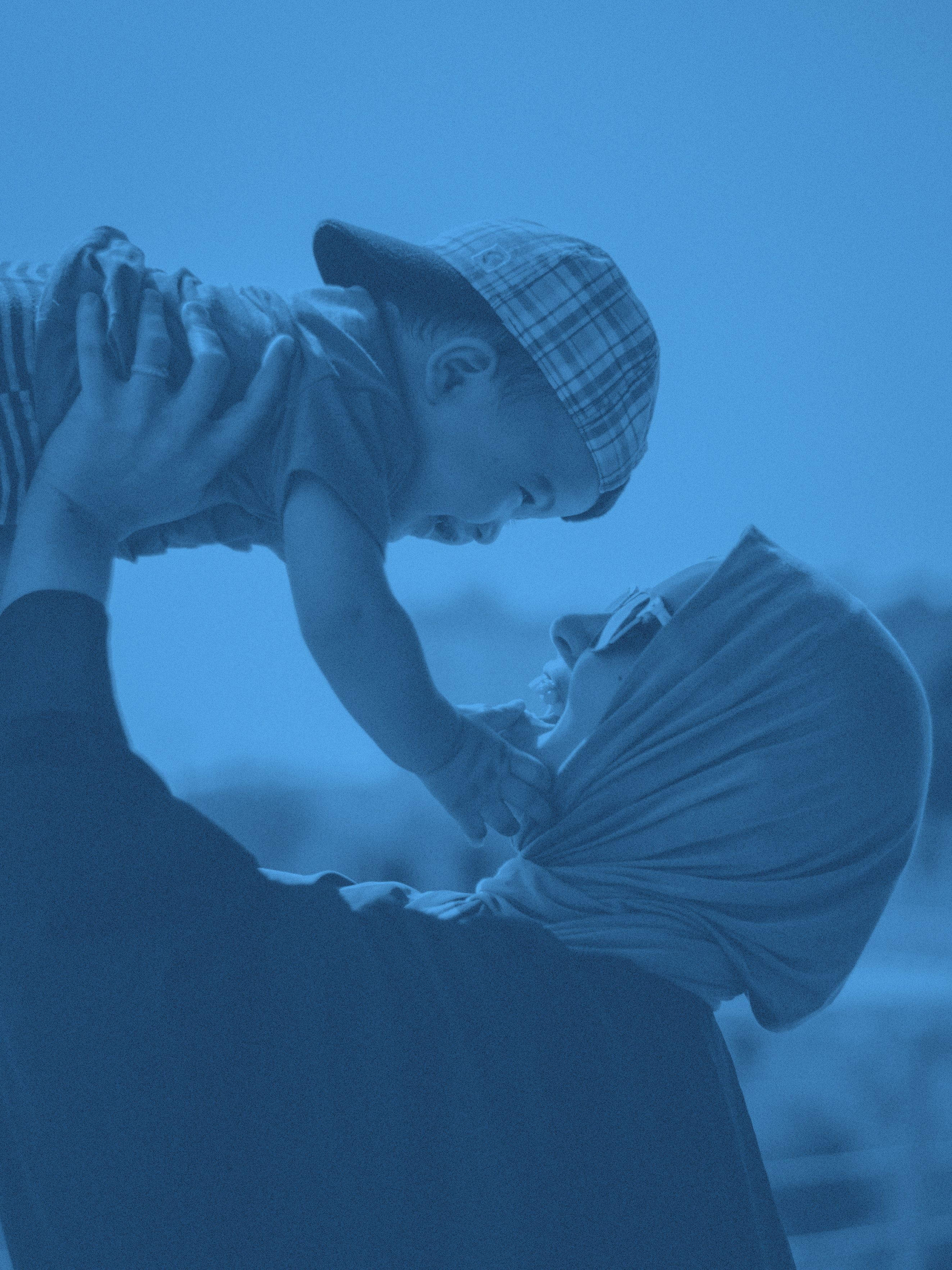 En mamma lyfter sitt barn mot himlen