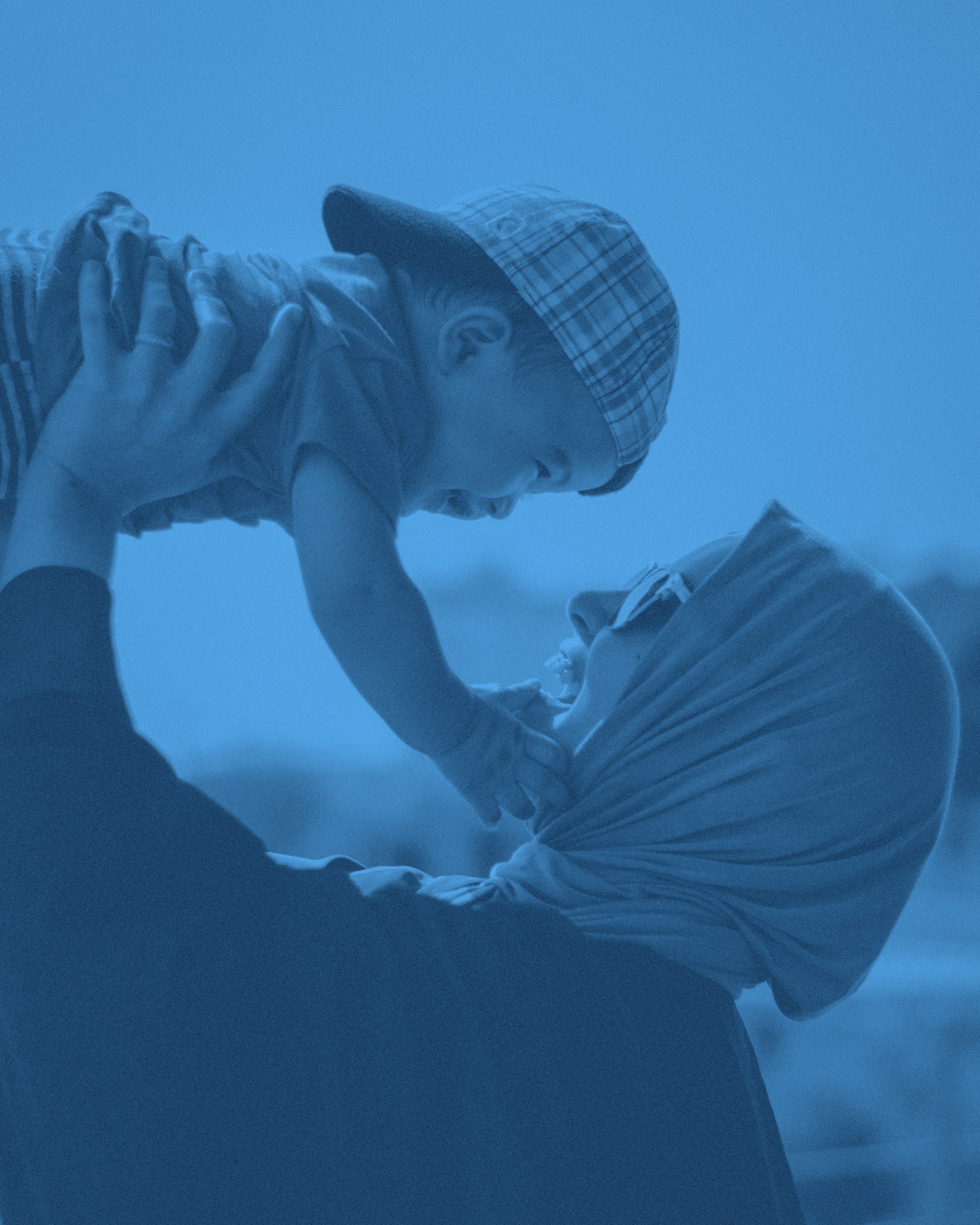 En mamma lyfter sitt barn mot himlen