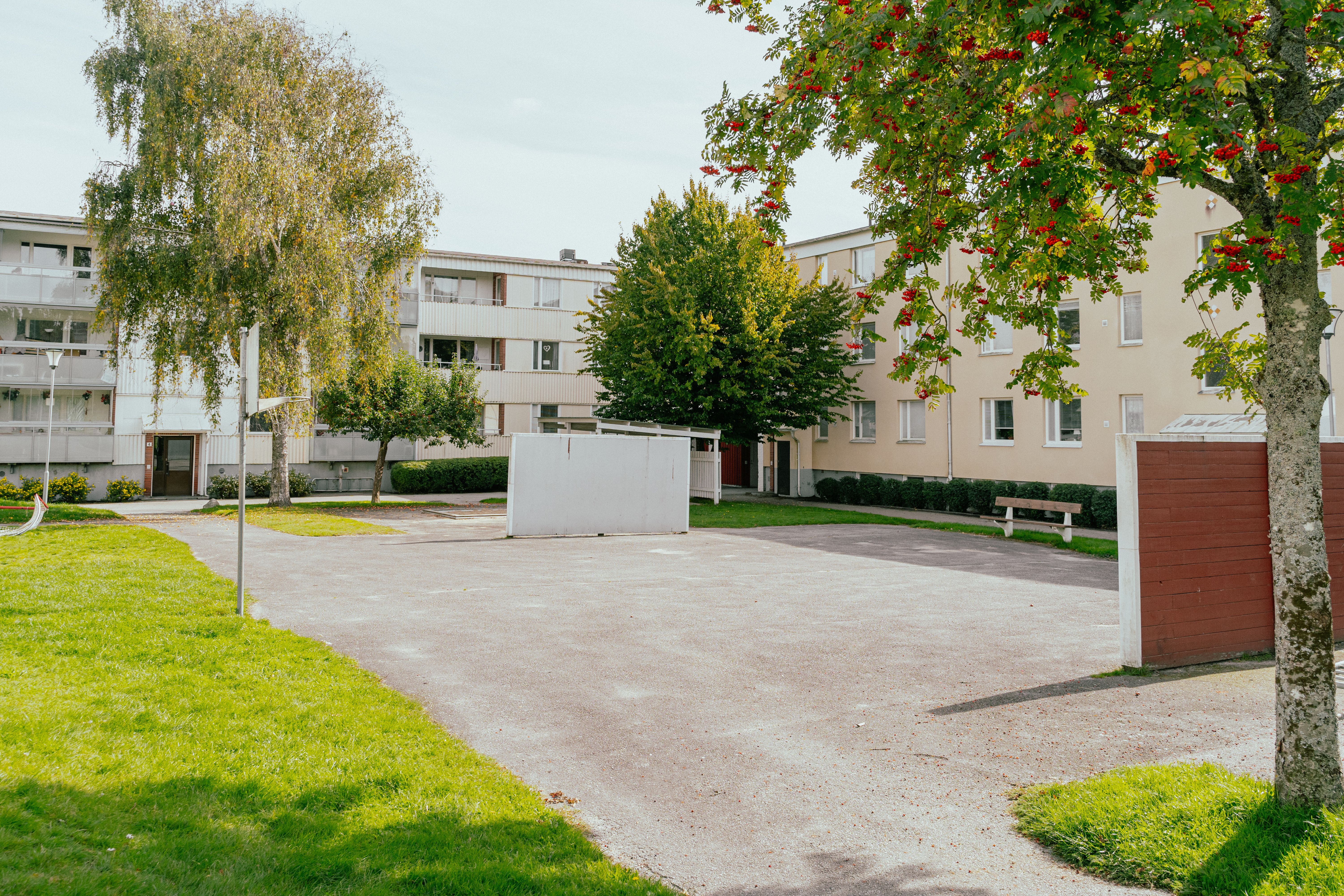 En asfalterad fotbollsplan i mitten av en stor gård