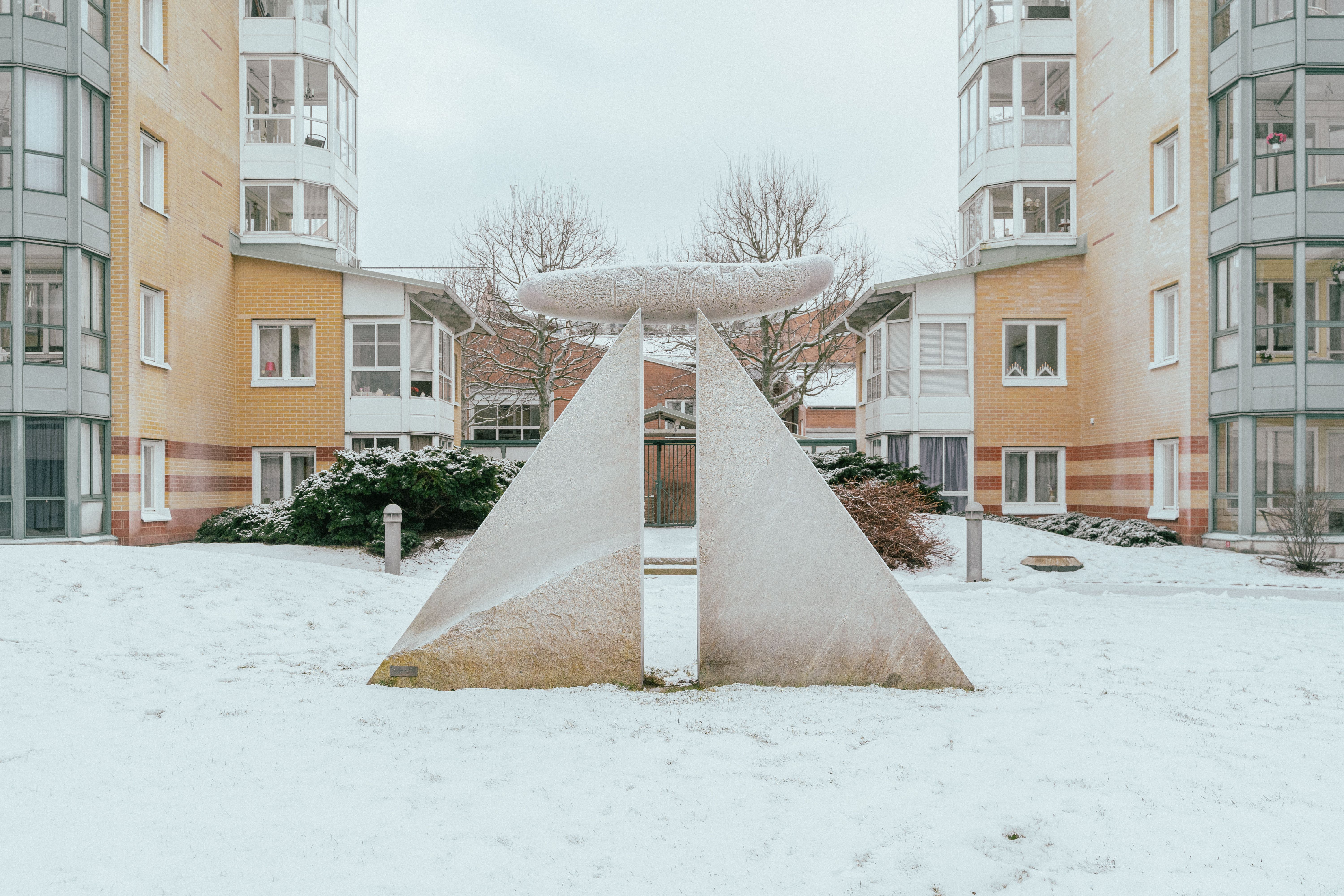 Ett konstverk i granit med två trekantiga stenblock med en cylinder på toppen