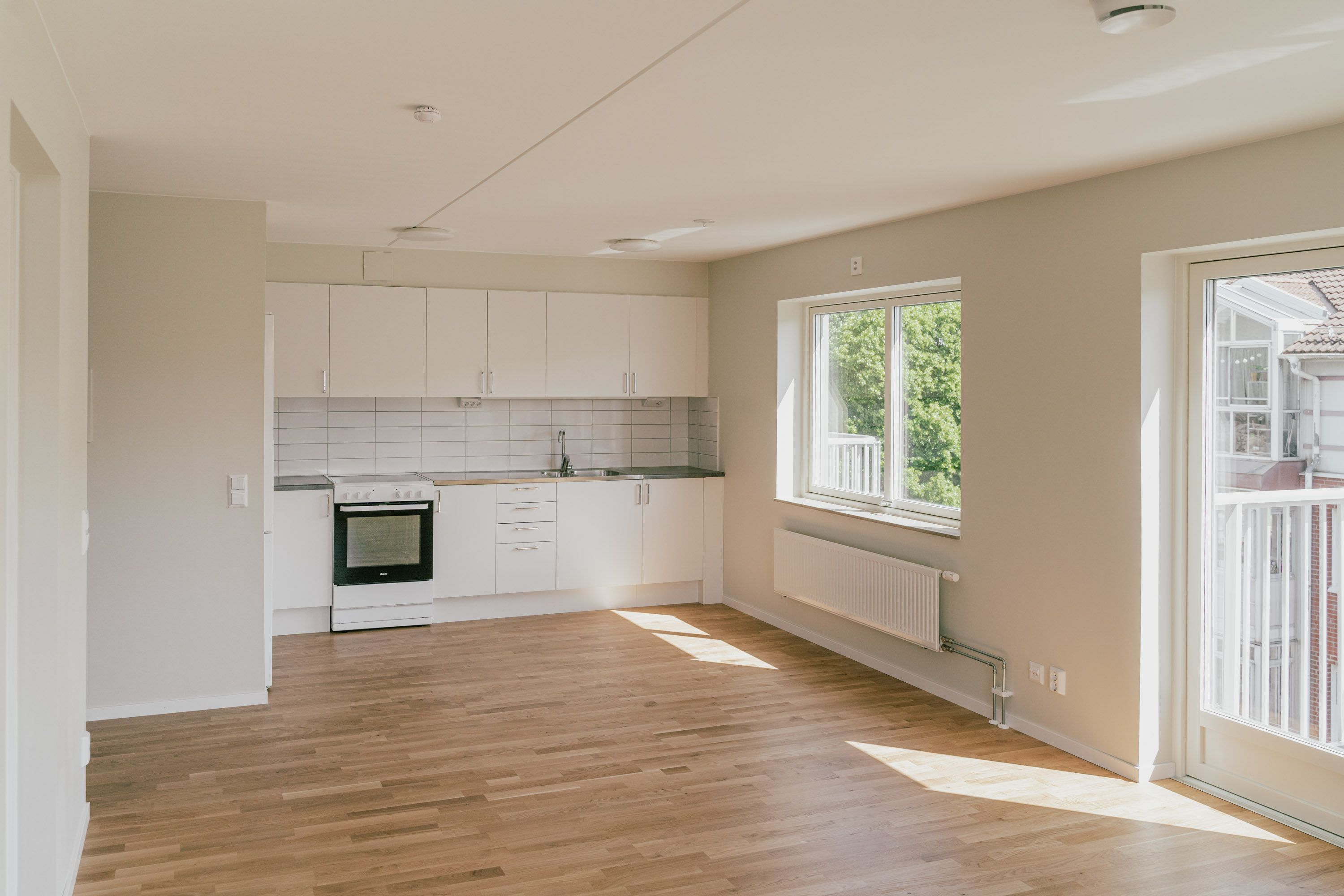 Ett tomt rum med ett kök i ena änden