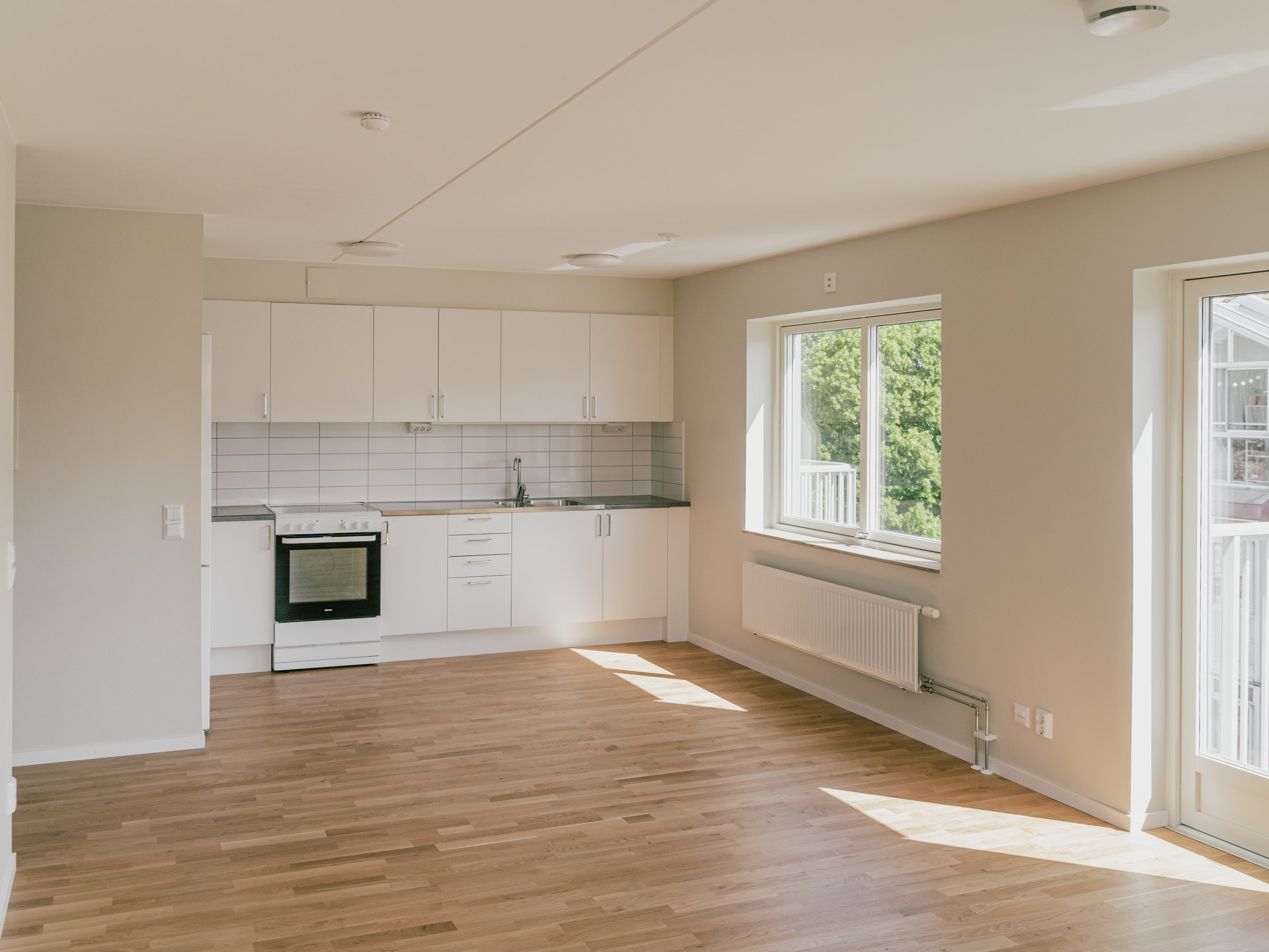 Ett tomt rum med ett kök i ena änden