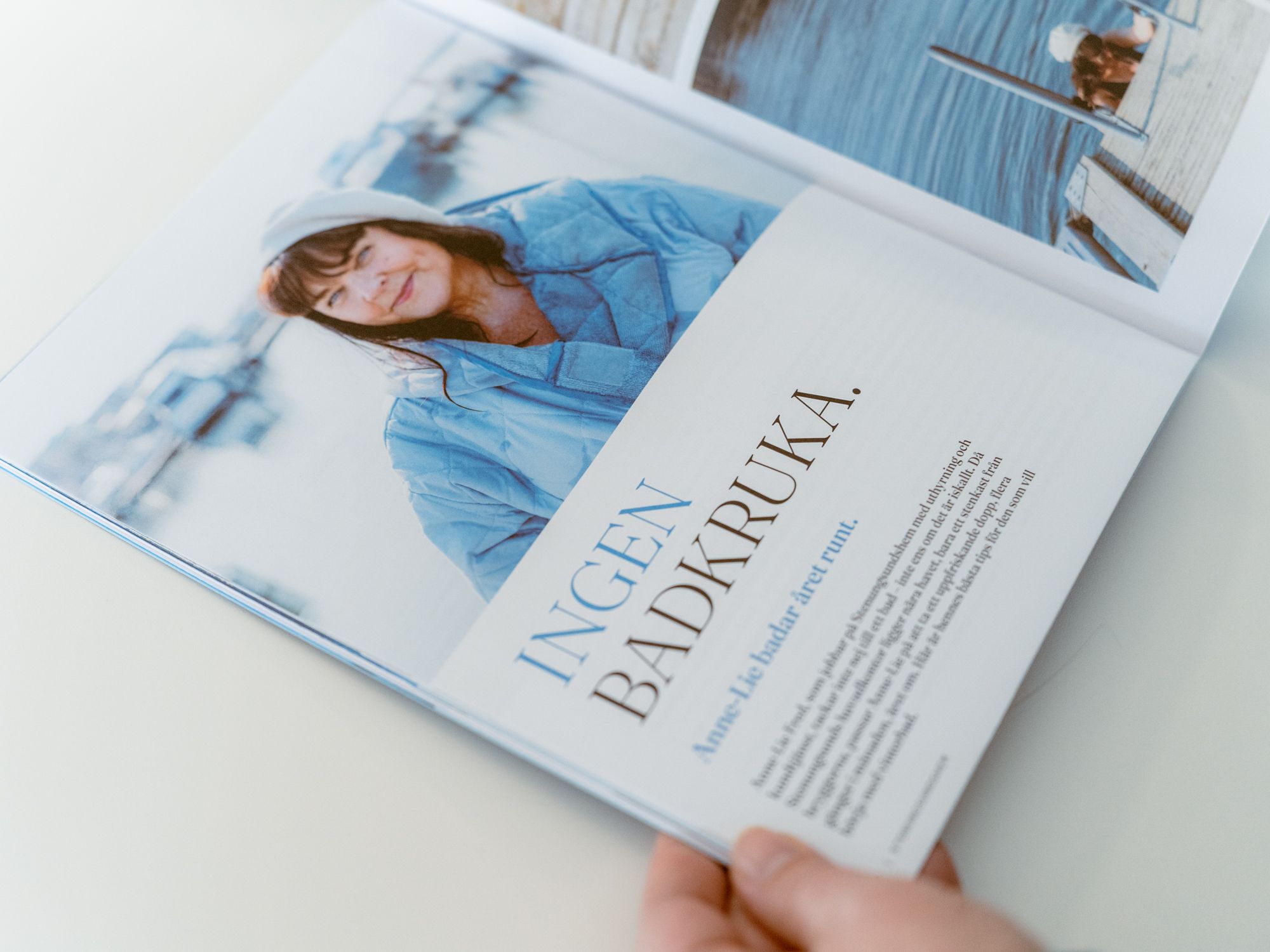 En hand håller upp ett uppslag av kundtidningen Lyhört