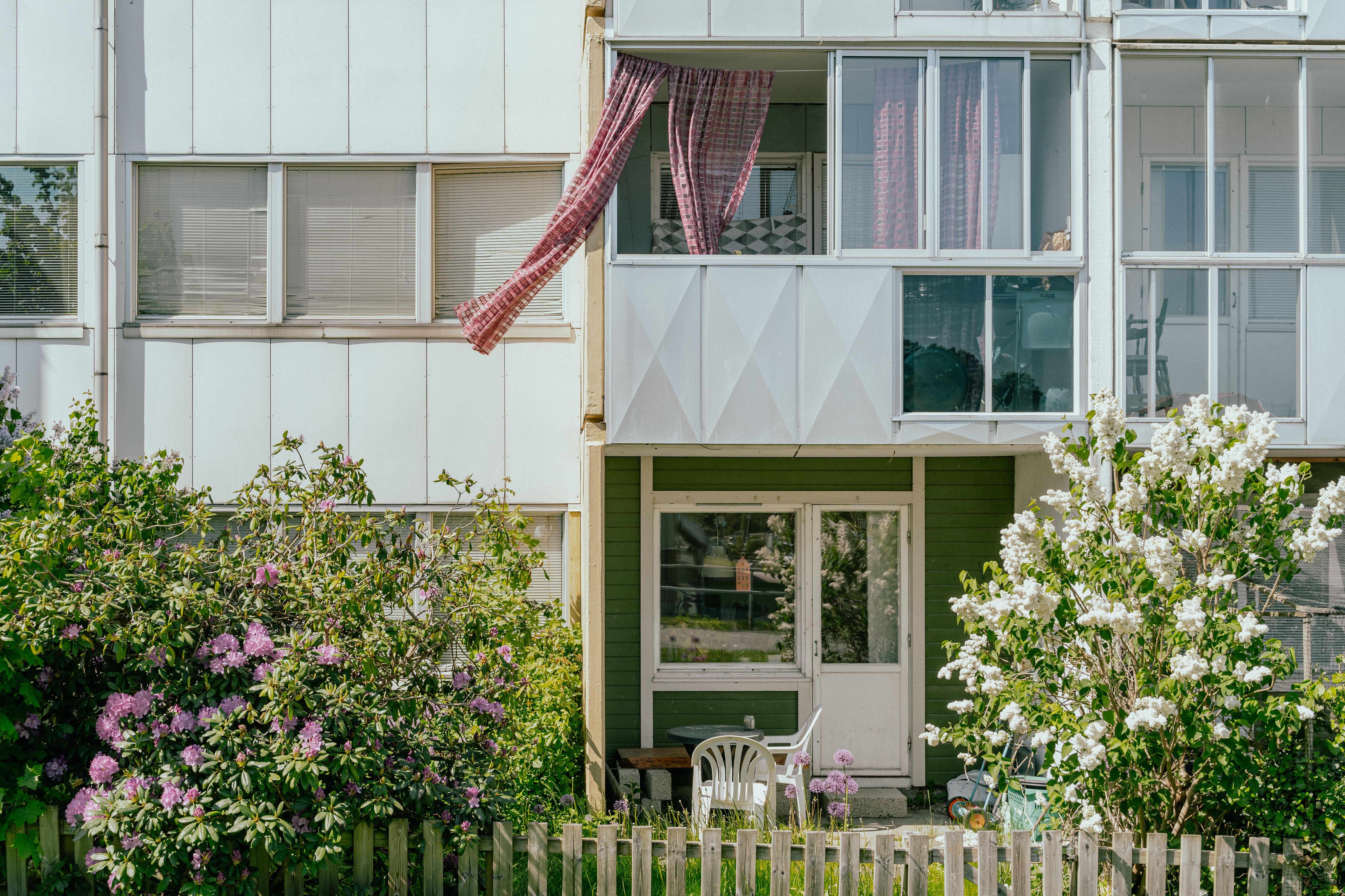 En uteplats och inglasad balkong med en fladdrande gardin