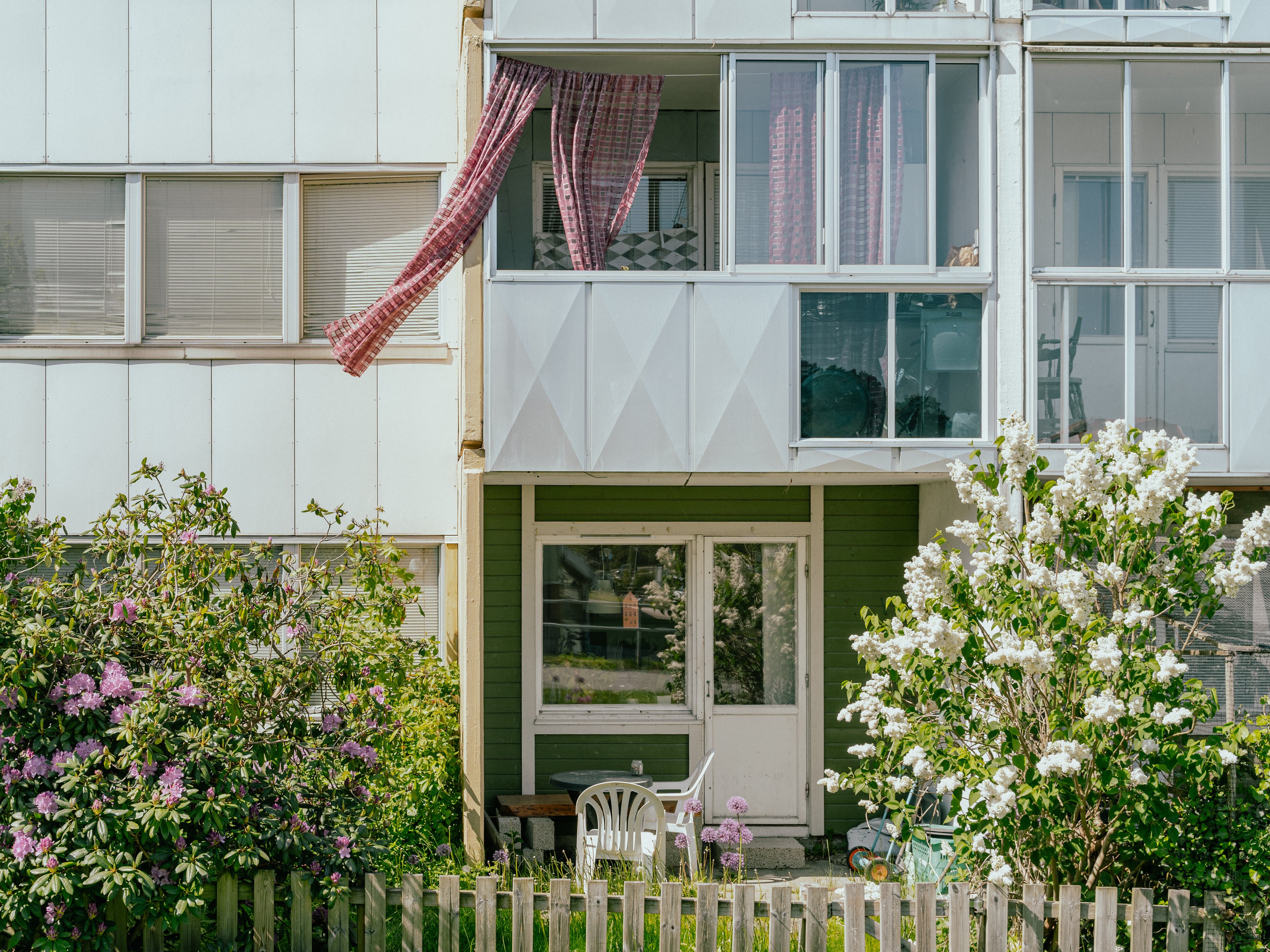 En uteplats och inglasad balkong med en fladdrande gardin