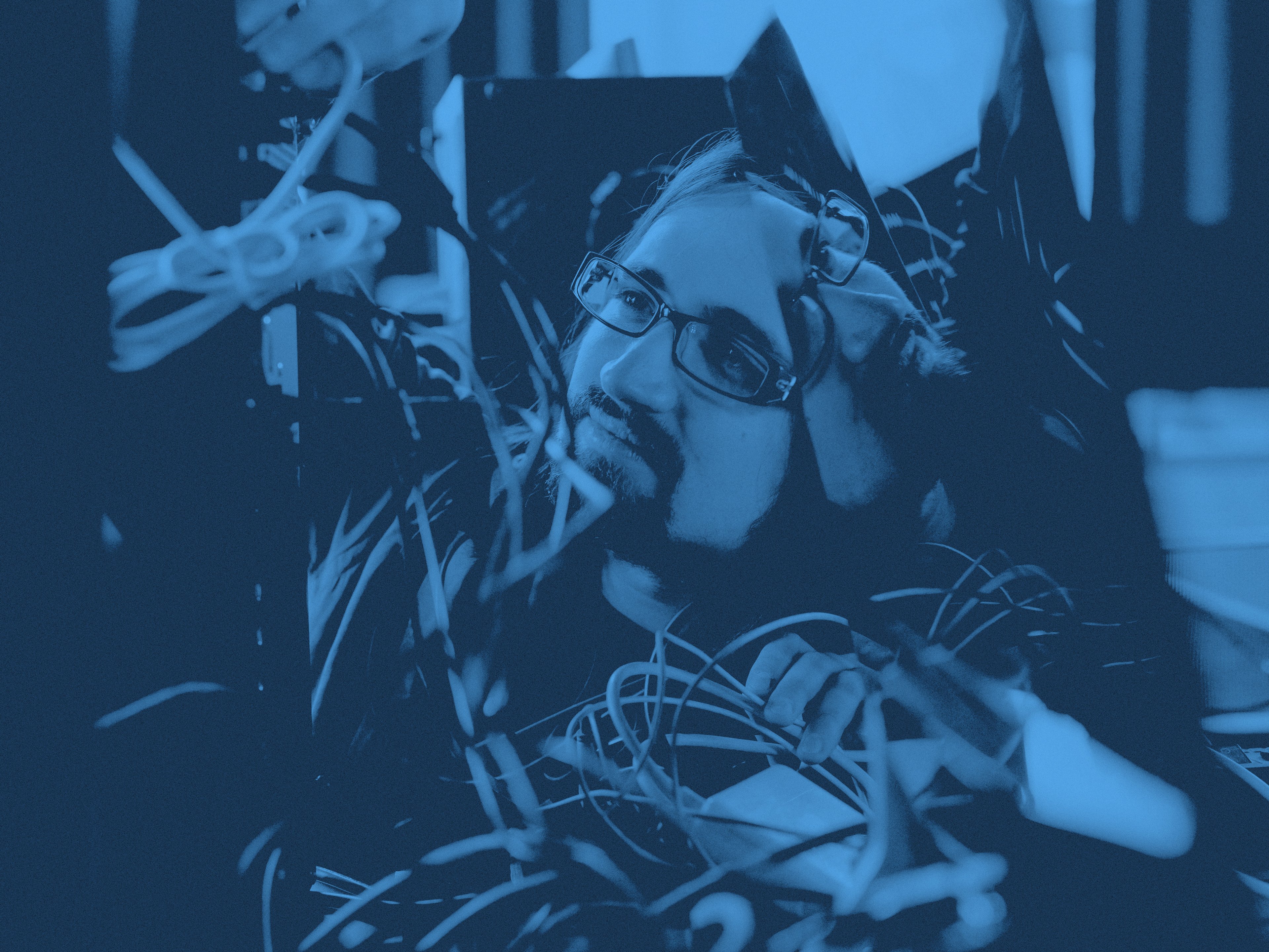 En person bakom sladdar och kablar