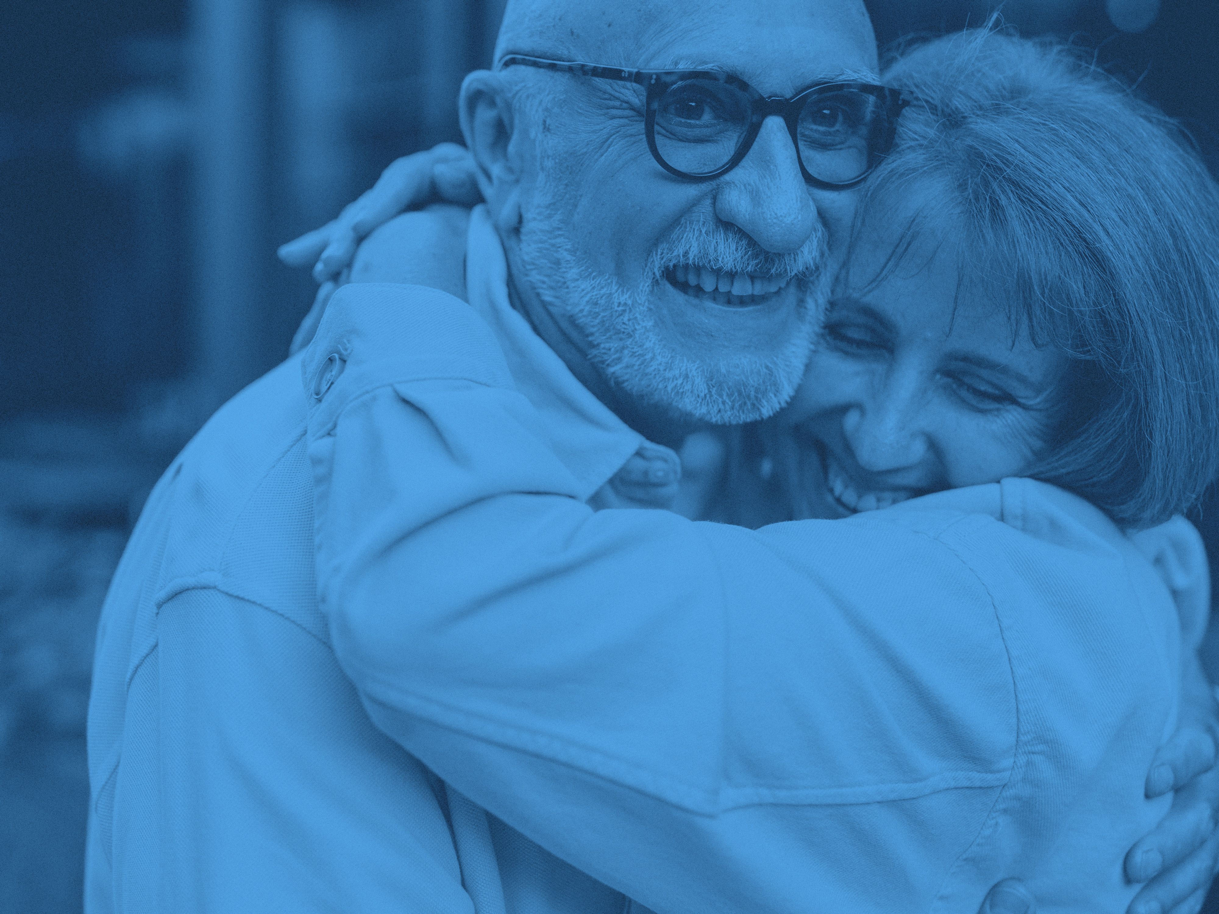 Två äldre personer kramas