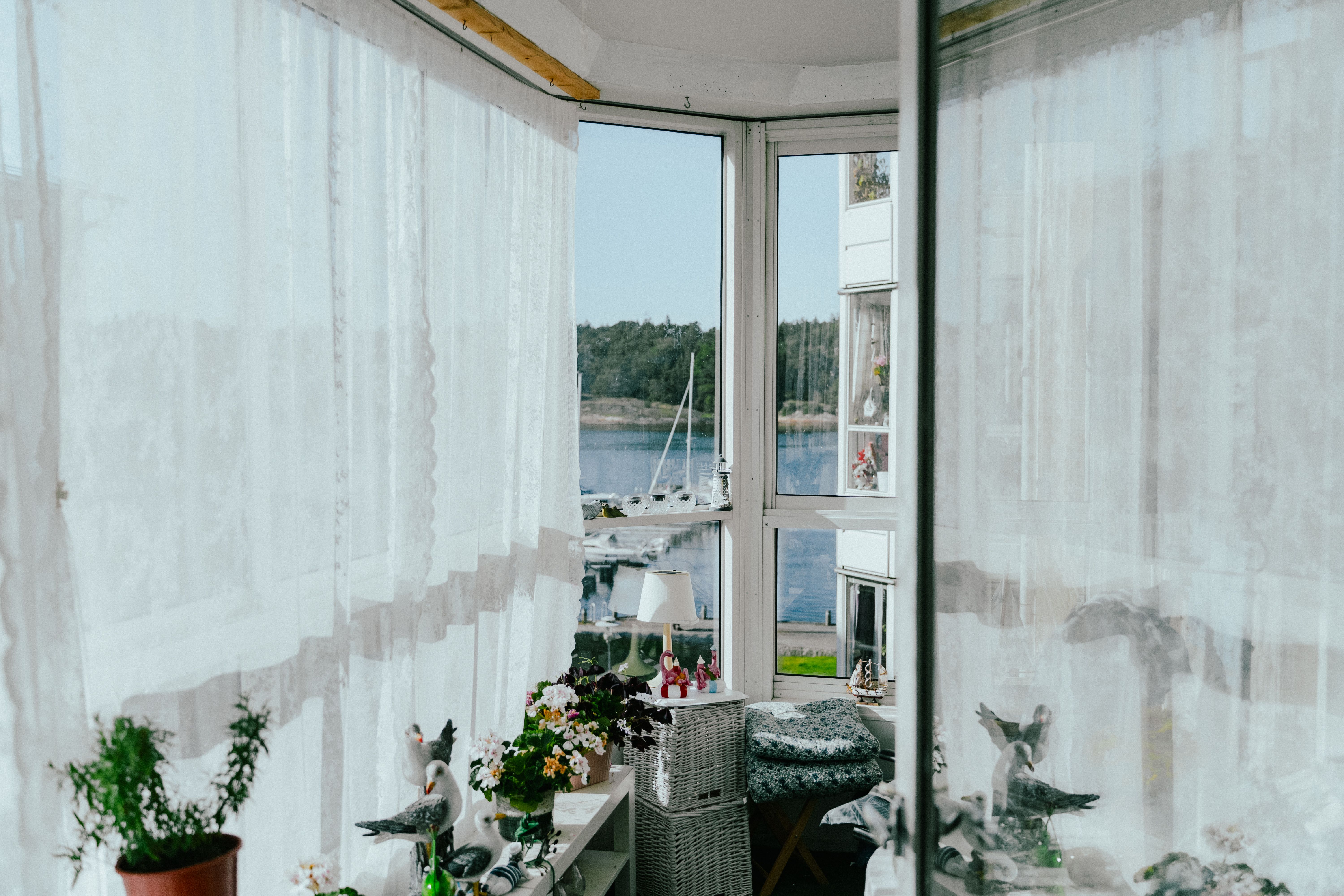 Inifrån en inglasad balkong med havsutsikt