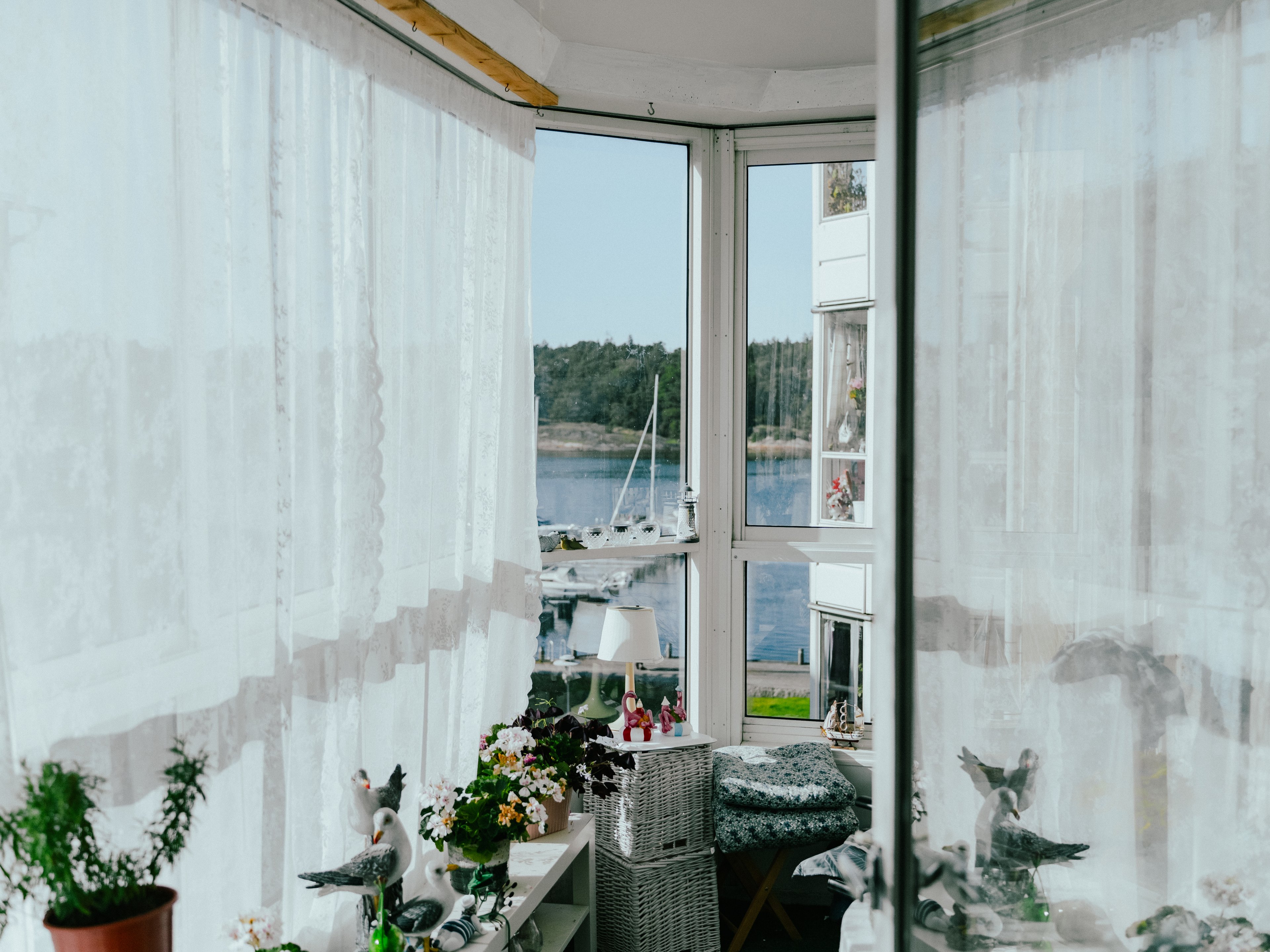 Inifrån en inglasad balkong med havsutsikt