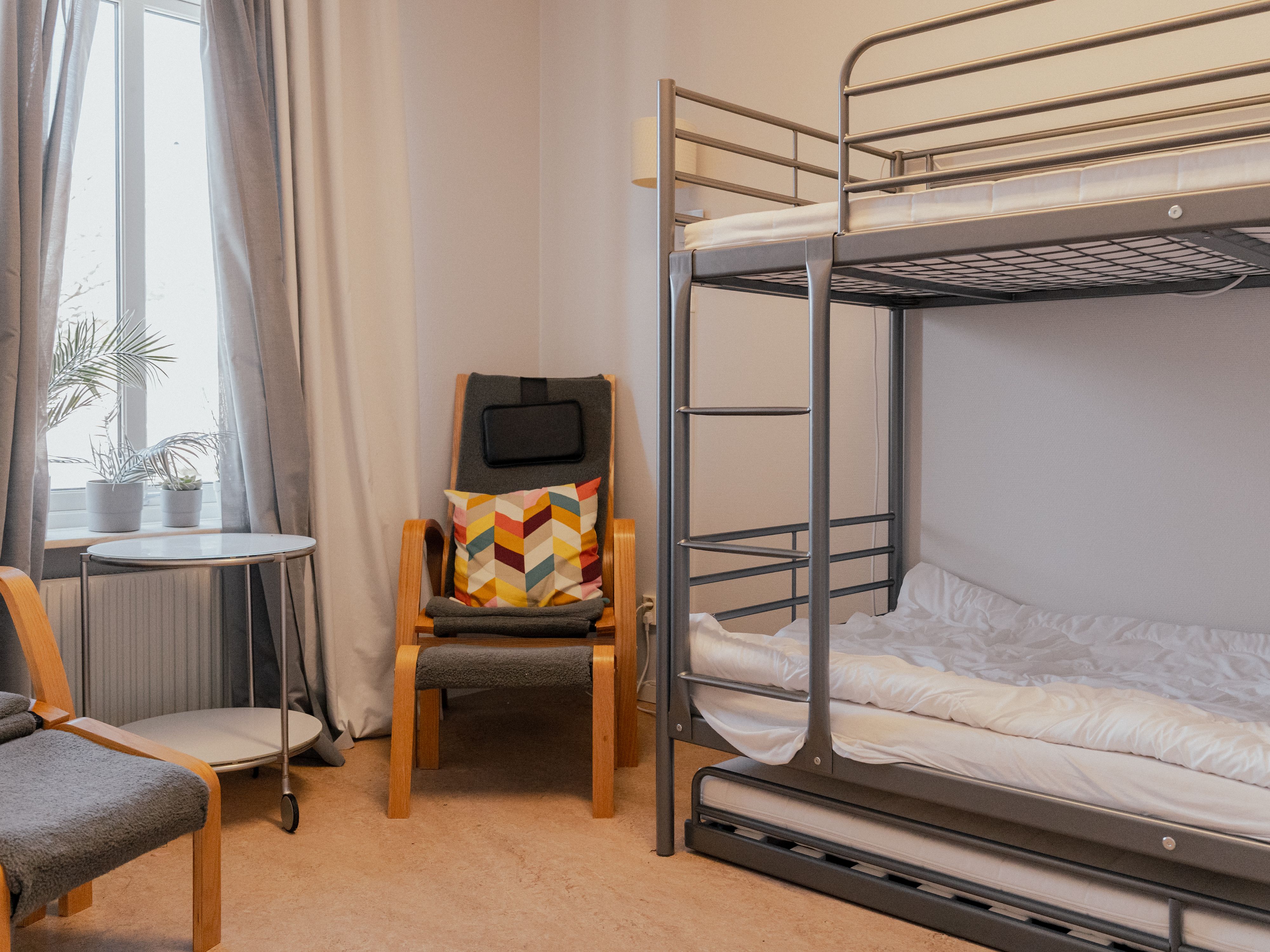 Ett gästrum med en fotölj och en våningssäng