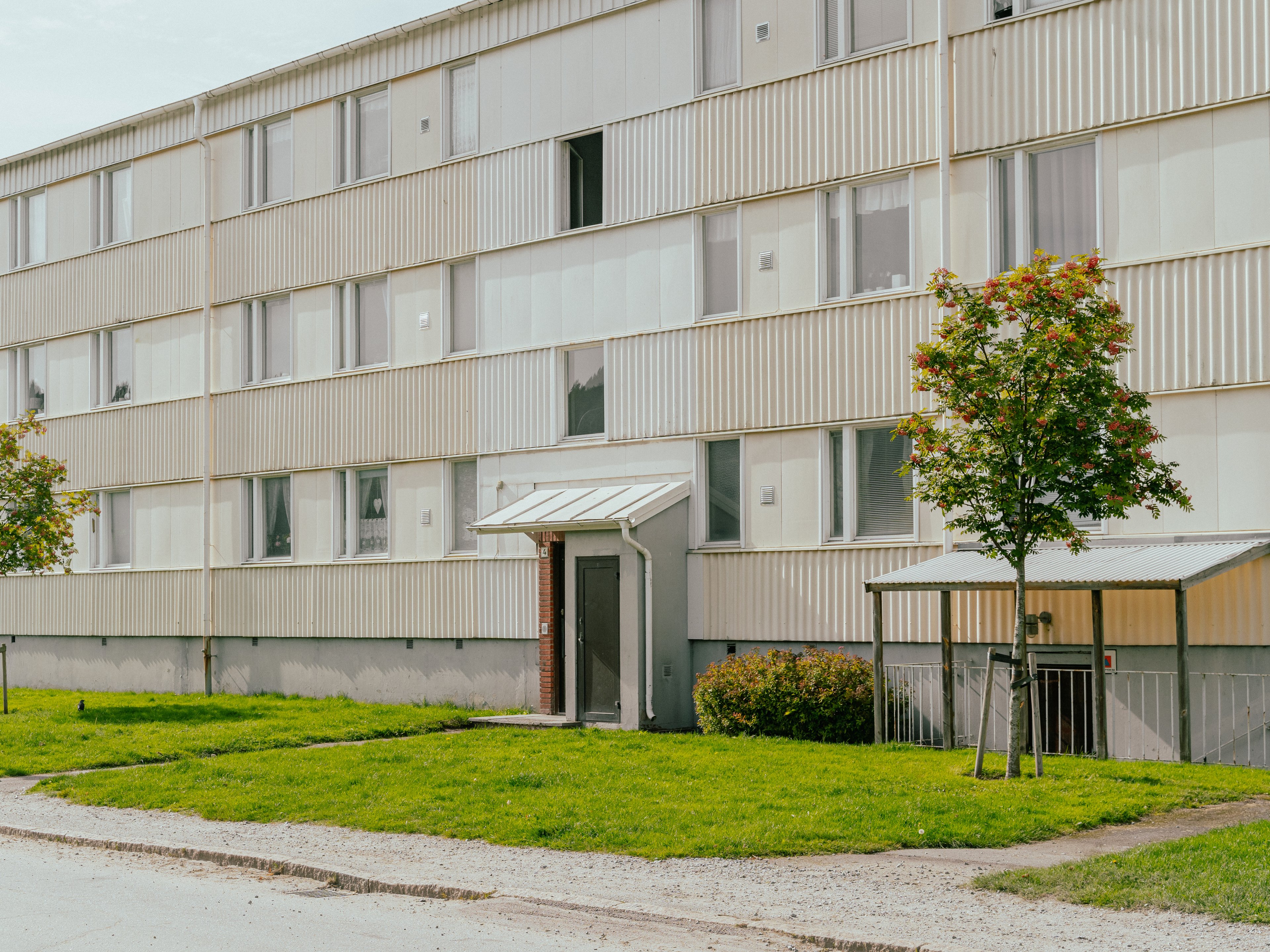 Fasaden av ett trevåningshus med träd framför