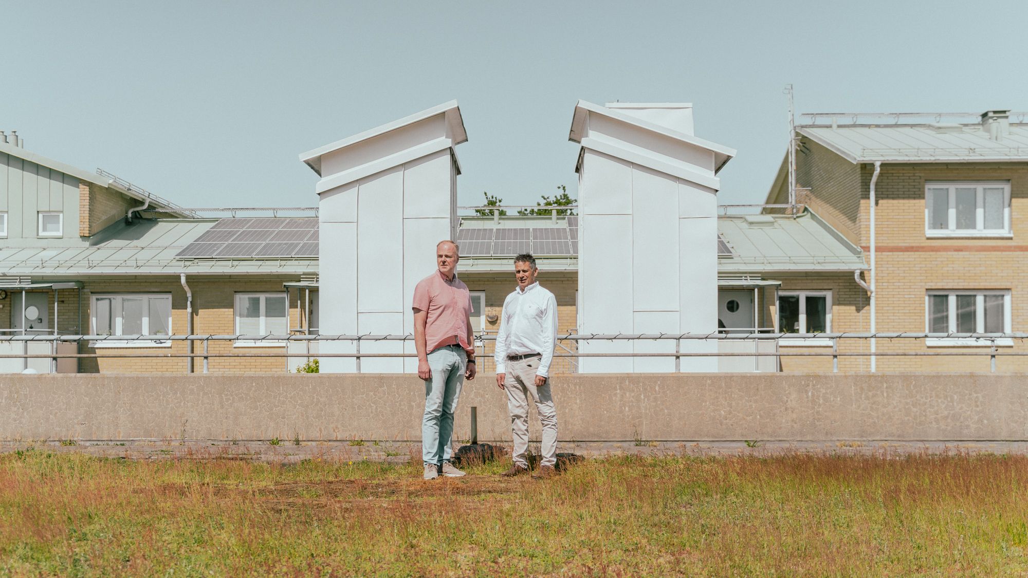 Två personer står på en gräsmatta