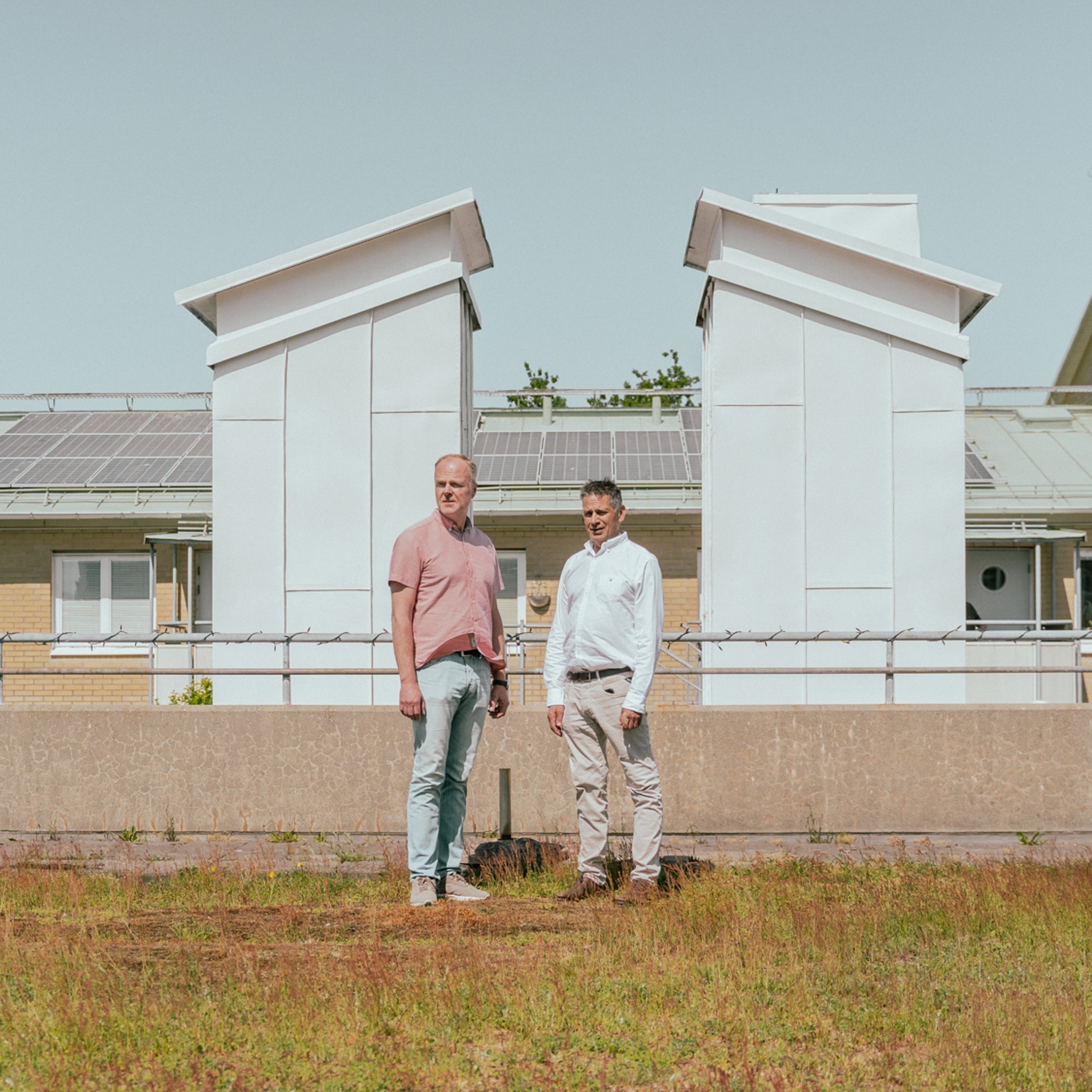 Två personer står på en gräsmatta