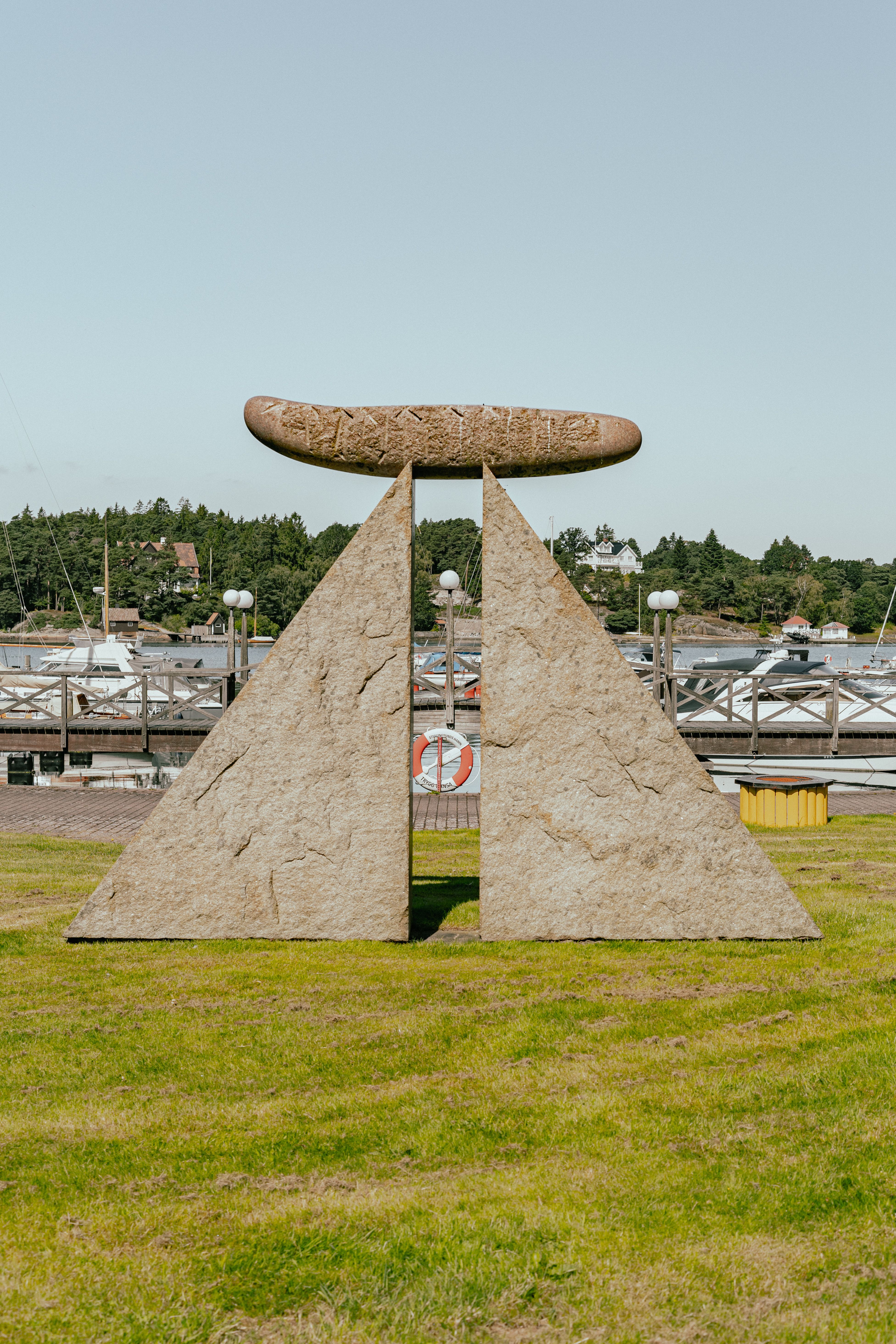 Ett konstverk i granit med två trekantiga stenblock med en cylinder på toppen
