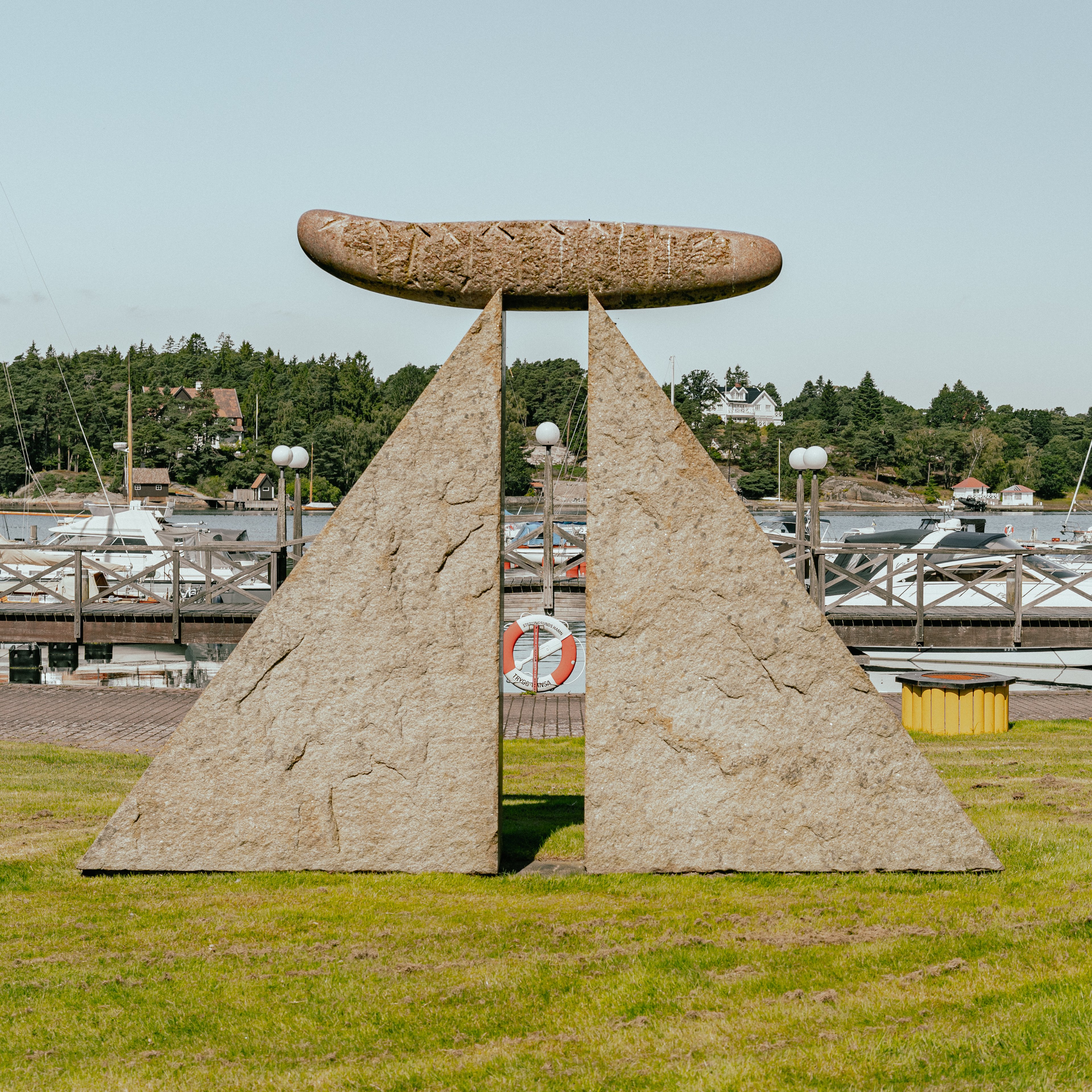 Ett konstverk i granit med två trekantiga stenblock med en cylinder på toppen