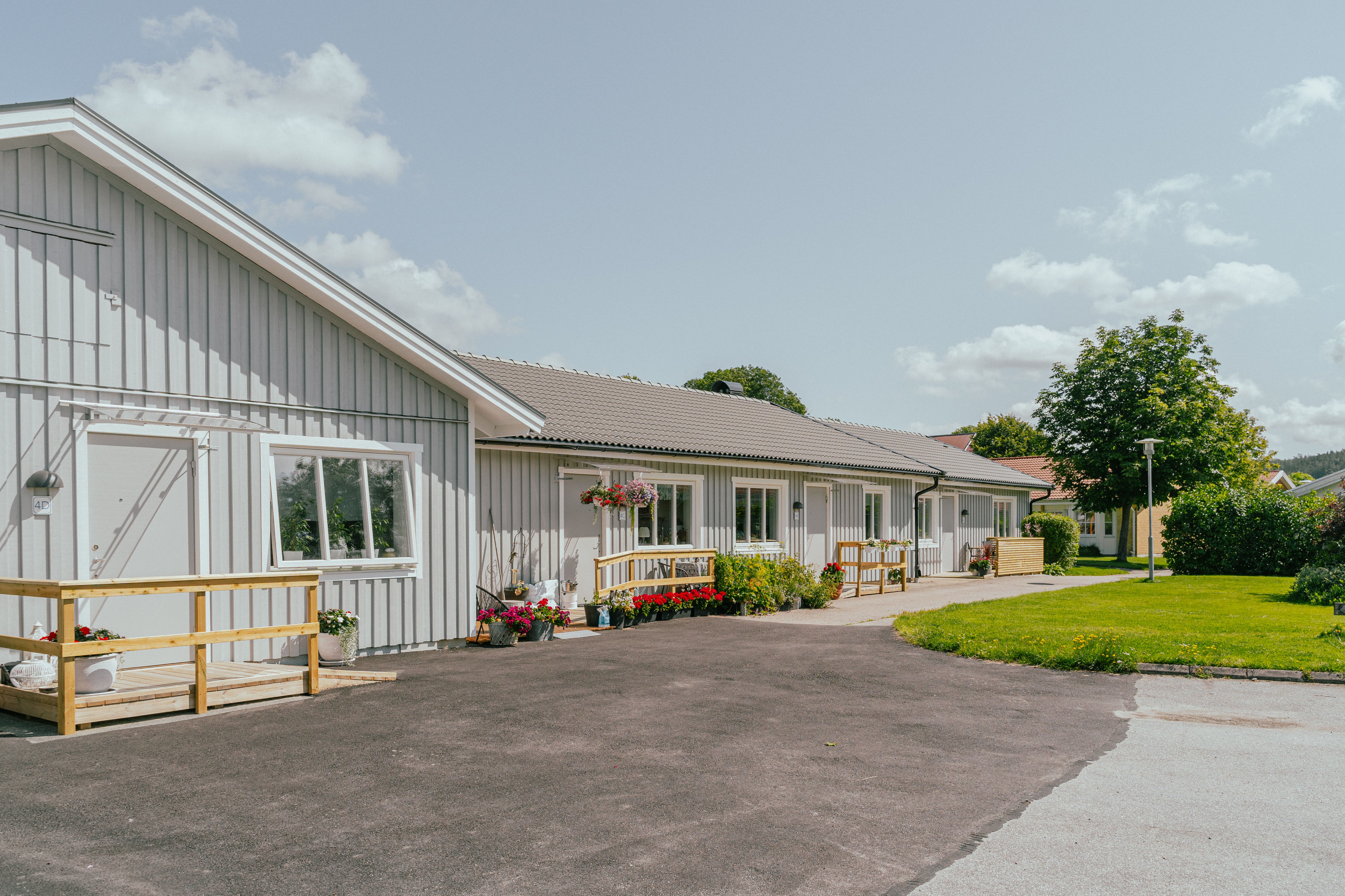 En huslänga med en asfalts-yta framför