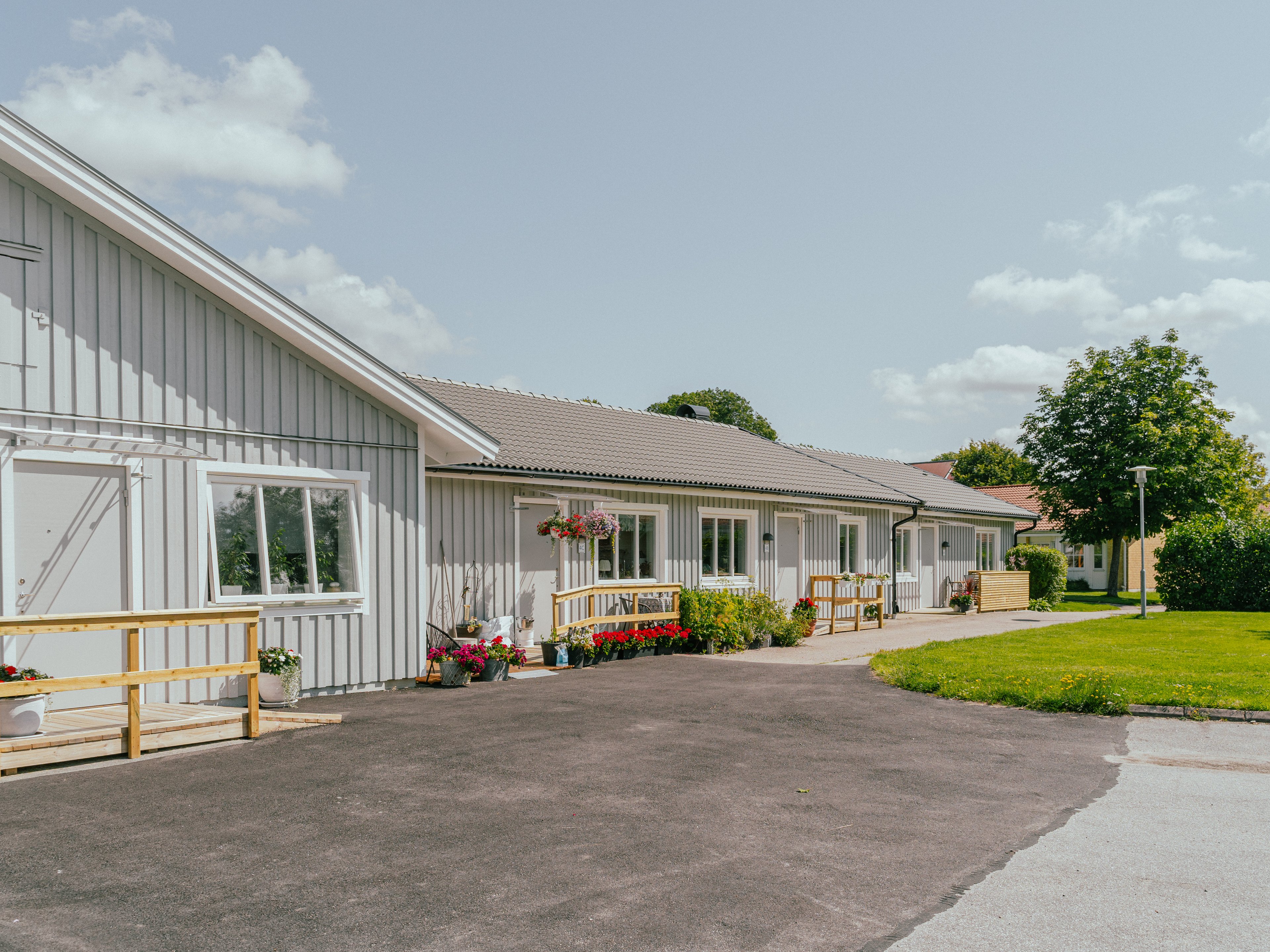 En huslänga med en asfalts-yta framför