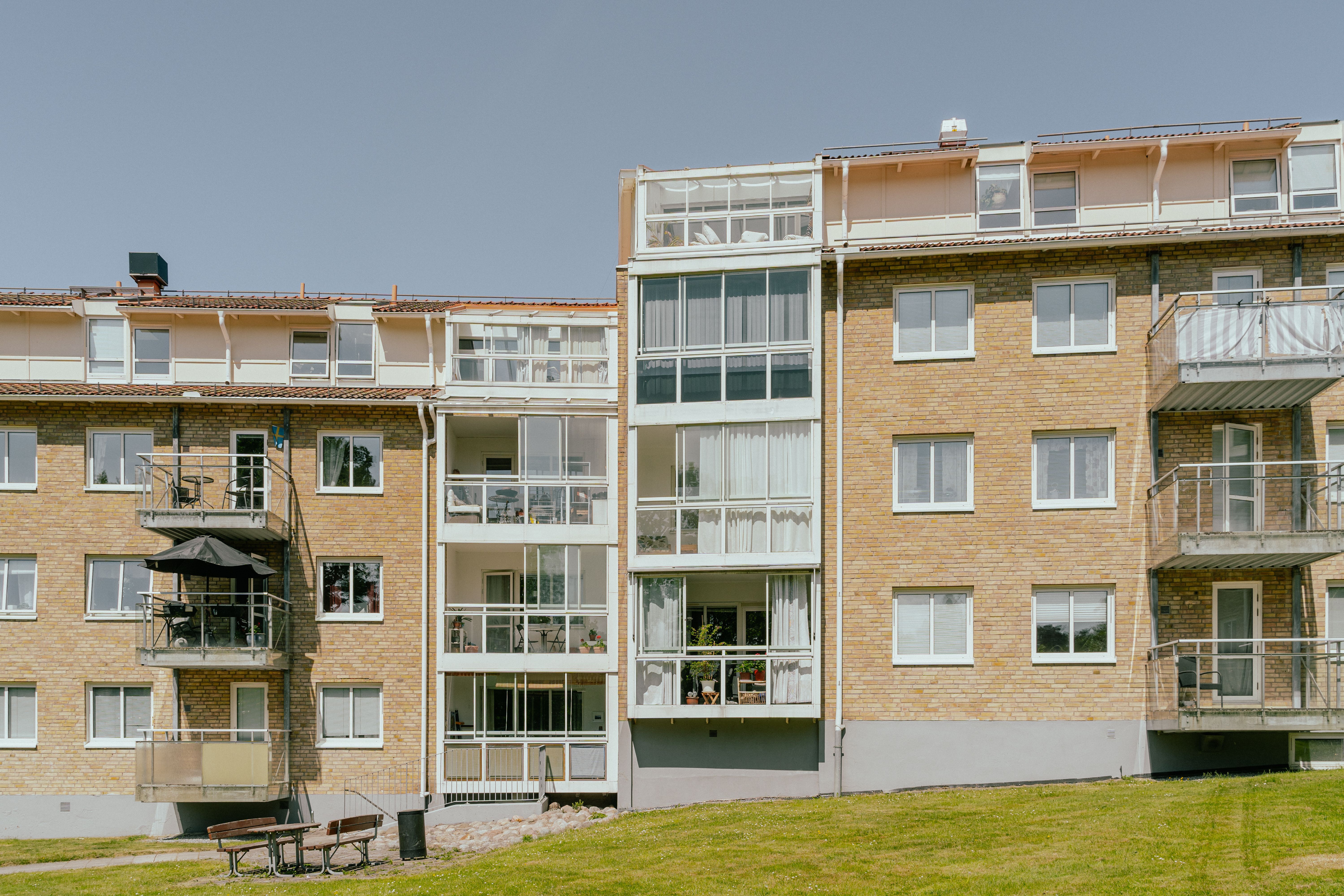En husfasad av ett fyravåningshus i tegel, och inglasade balkonger