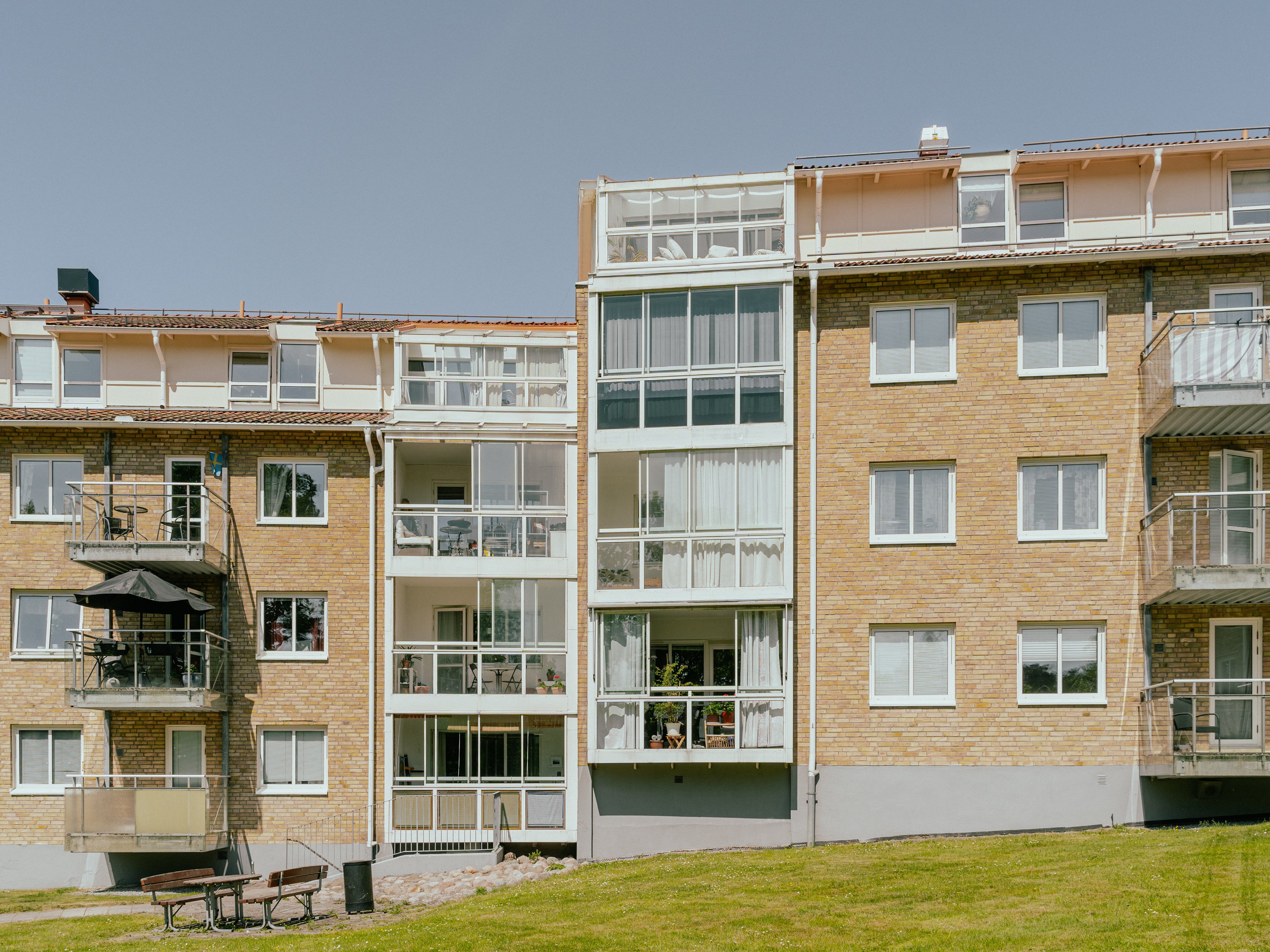 En husfasad av ett fyravåningshus i tegel, och inglasade balkonger