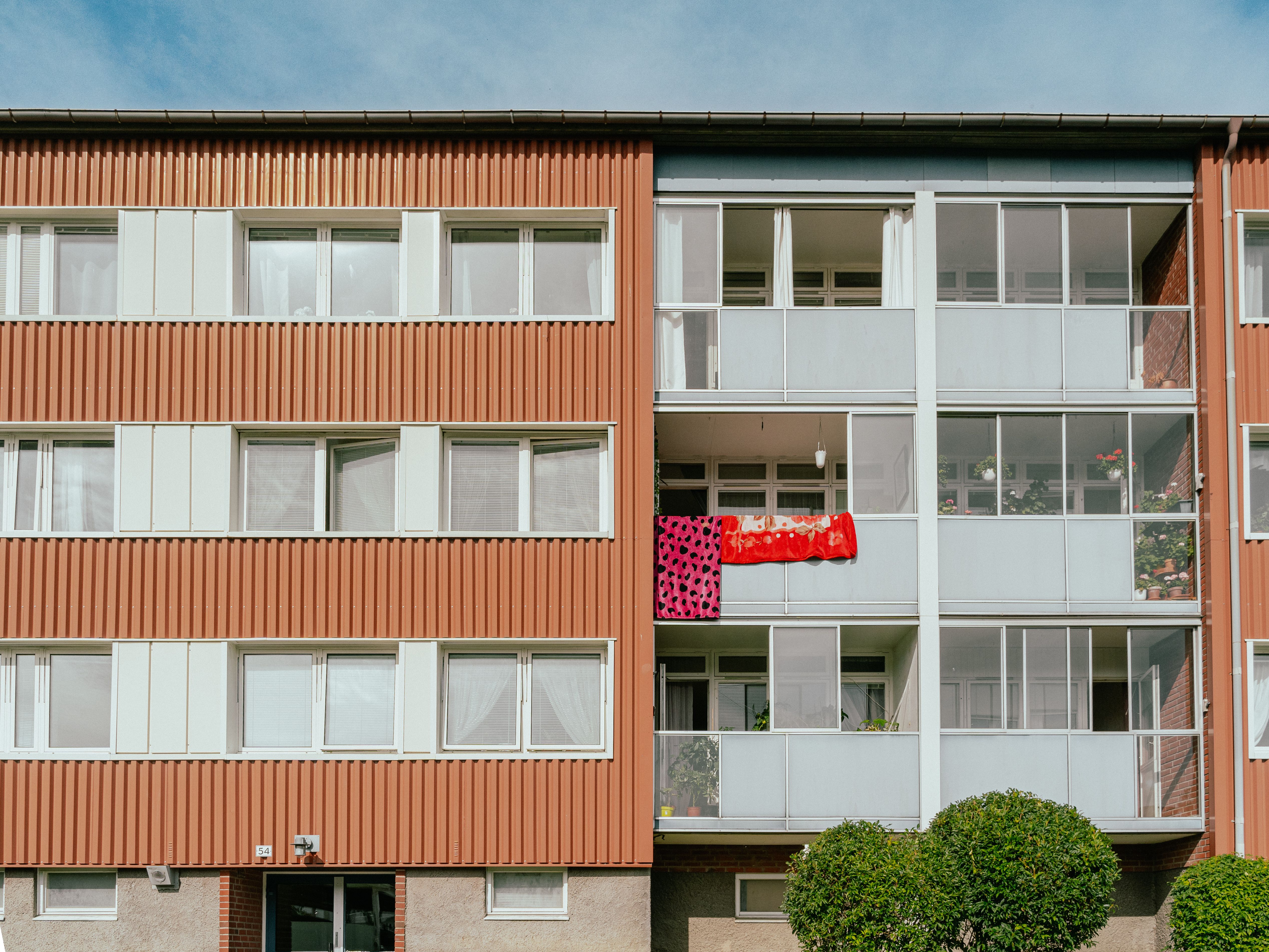 En husfasad med balkonger där någon vädrar filtar
