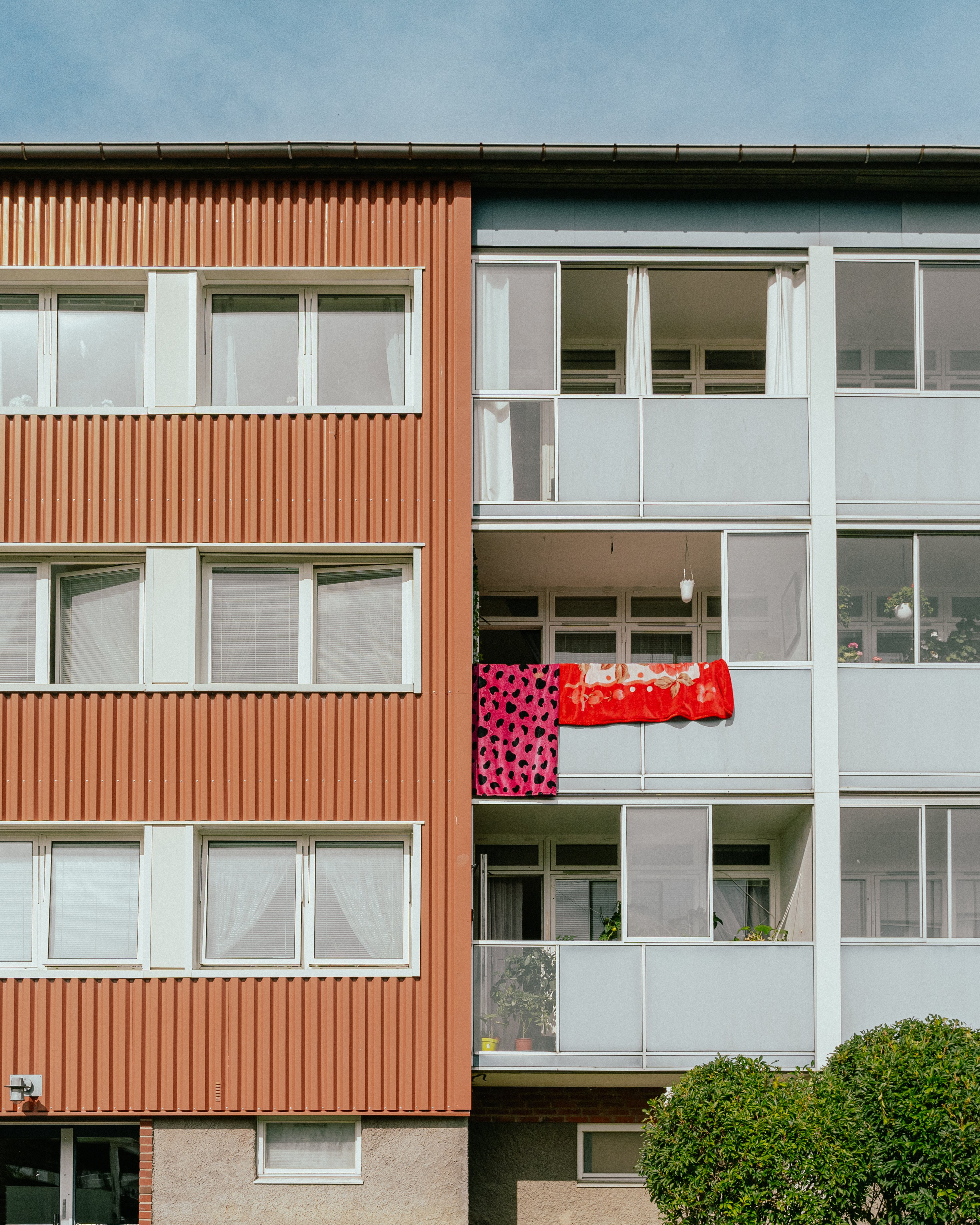 En husfasad med balkonger där någon vädrar filtar
