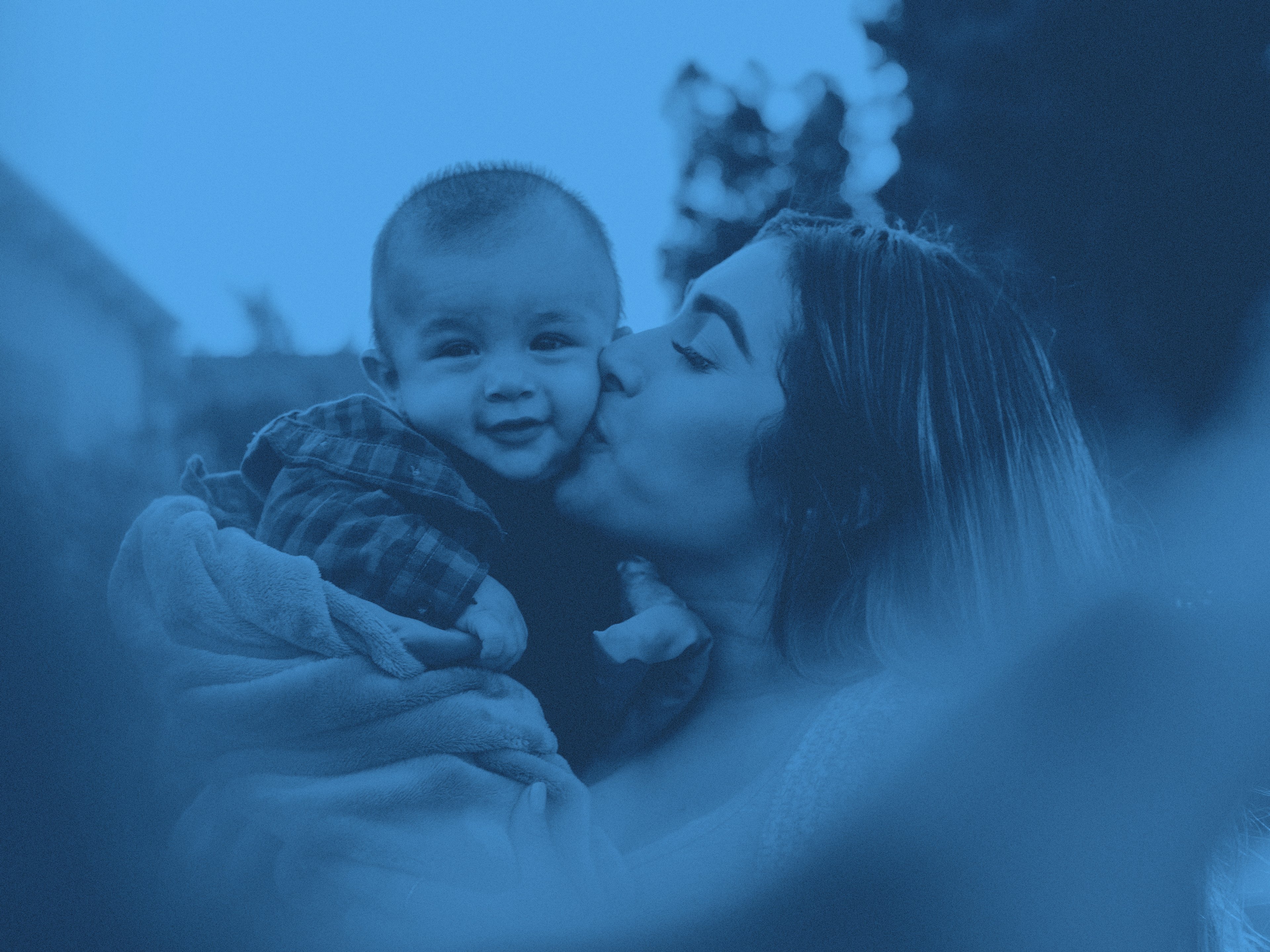 En mamma pussar litet barn på kinden