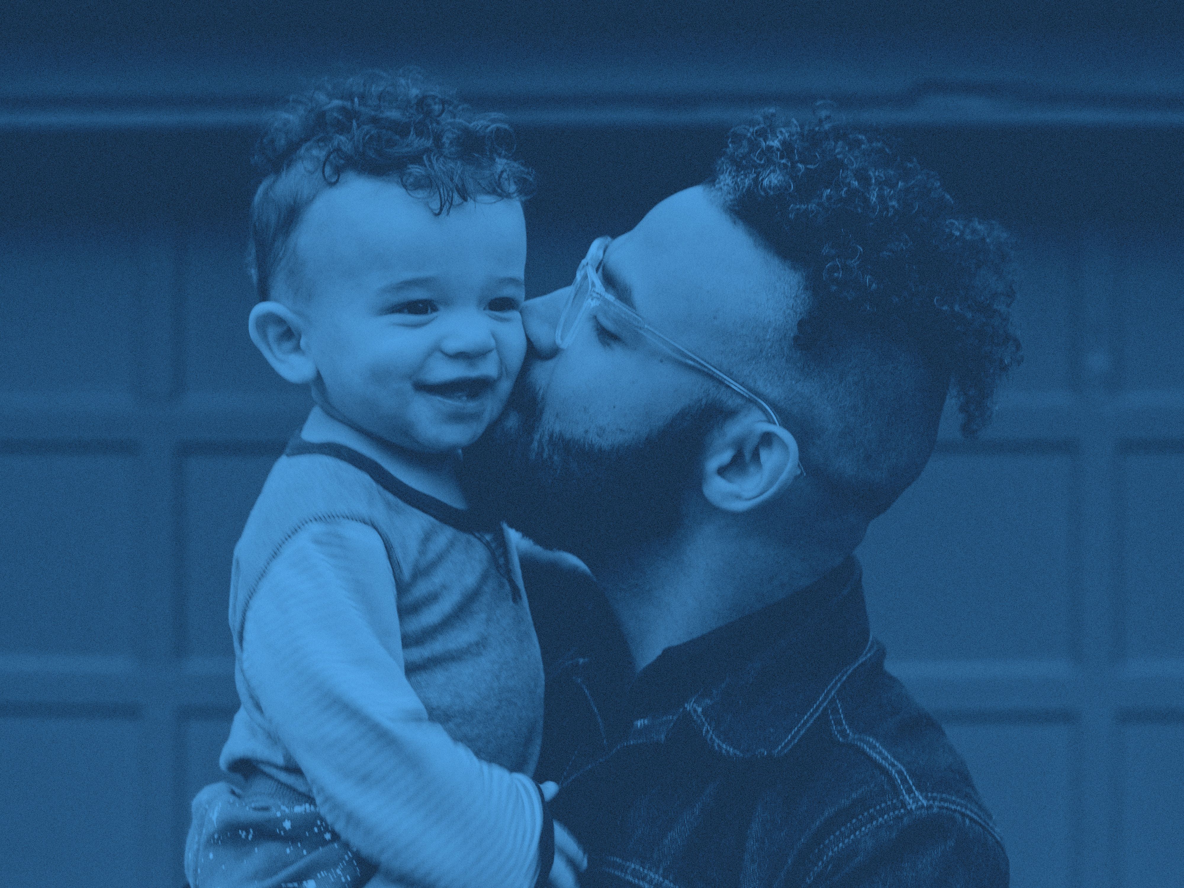 En pappa pussar barn på kinden