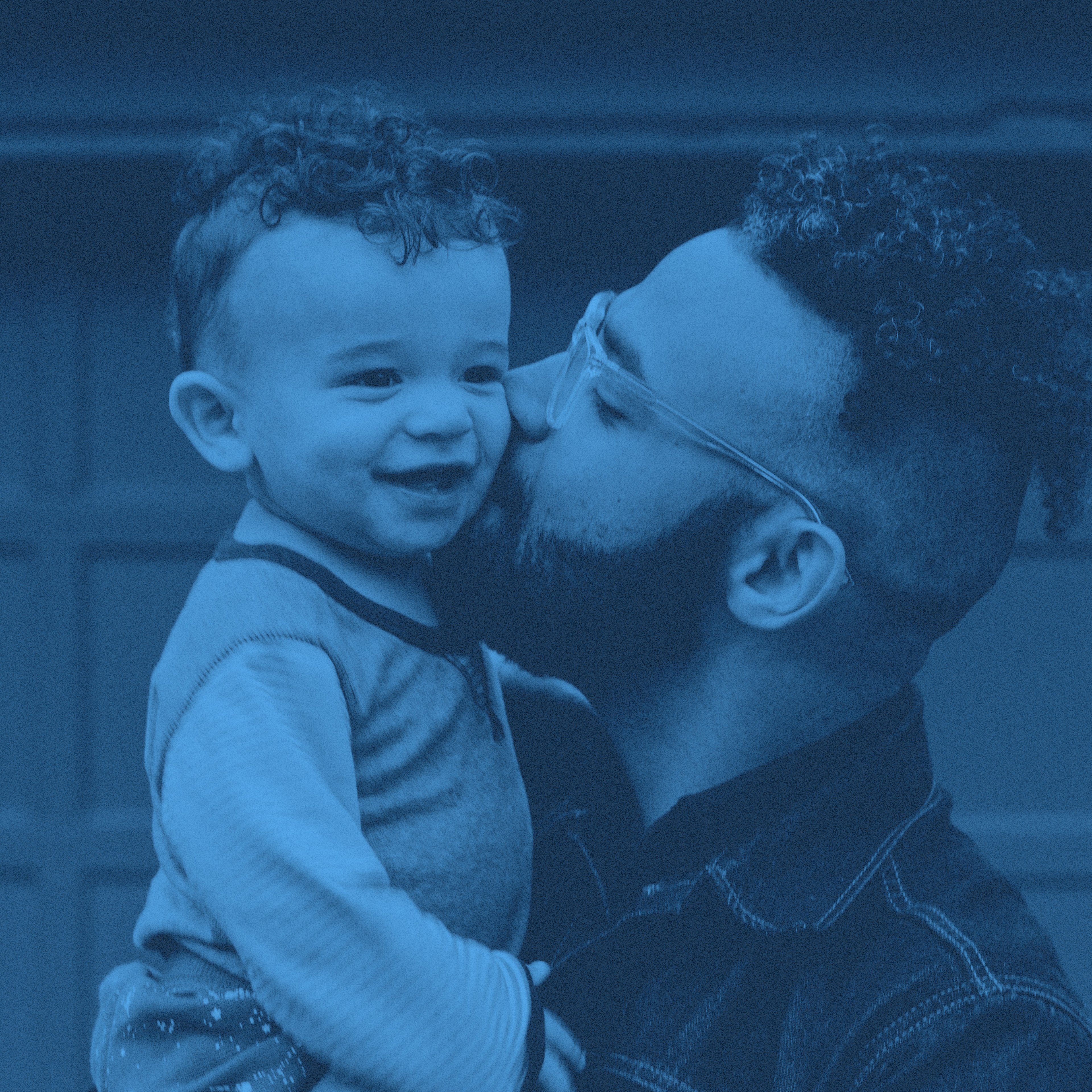 En pappa pussar barn på kinden