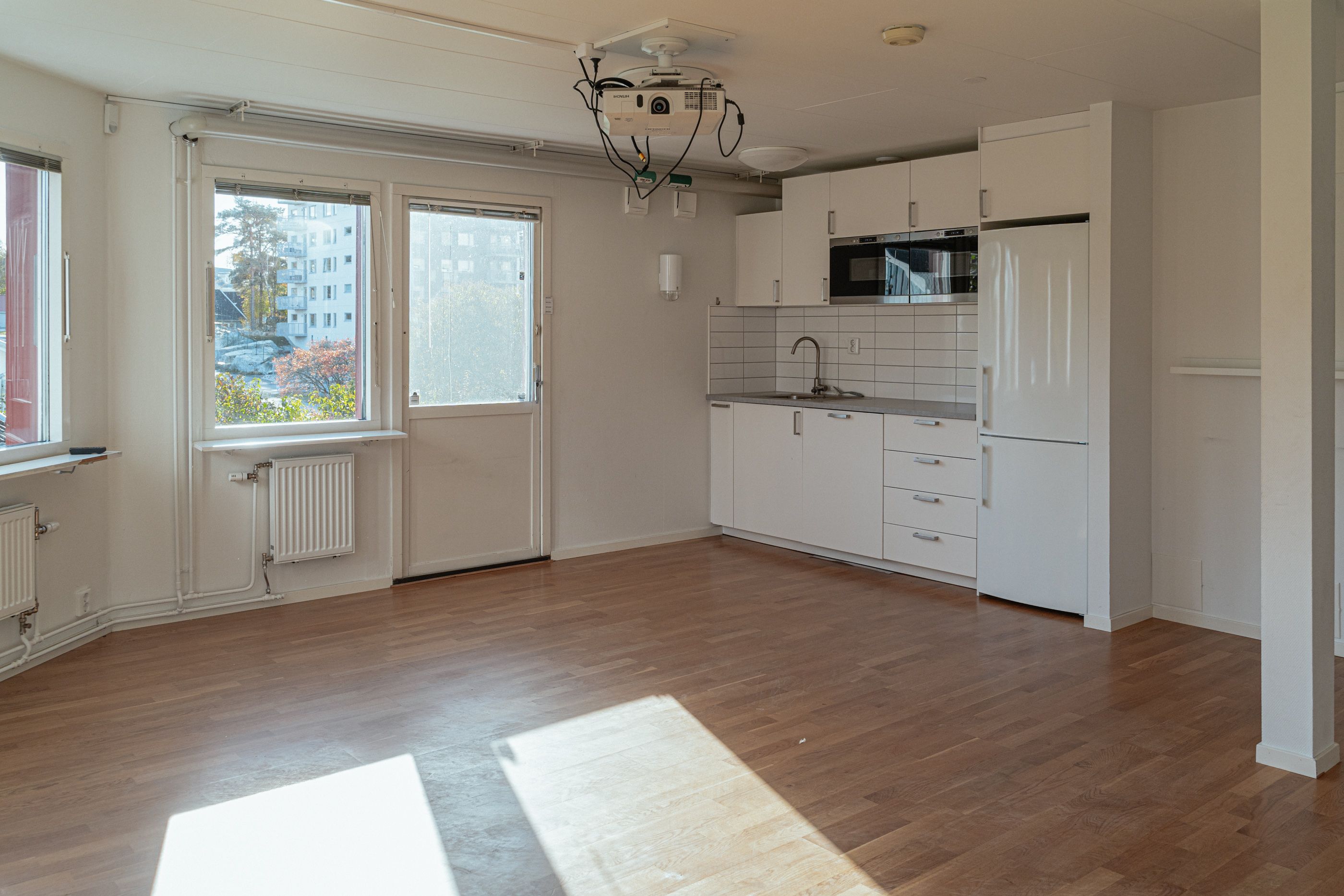 En tom kontorslokal med ett trinettkök i ena änden