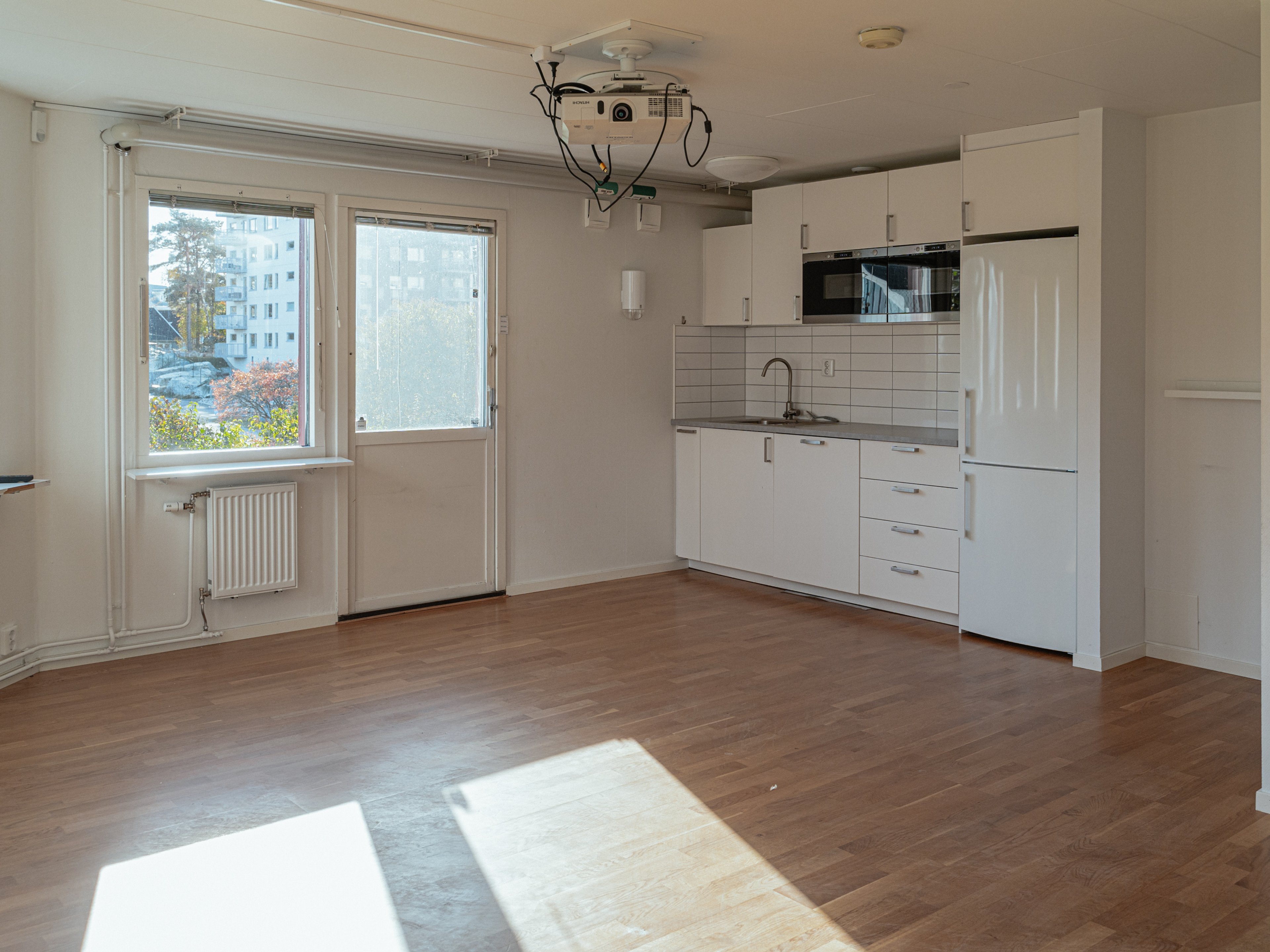 En tom kontorslokal med ett trinettkök i ena änden