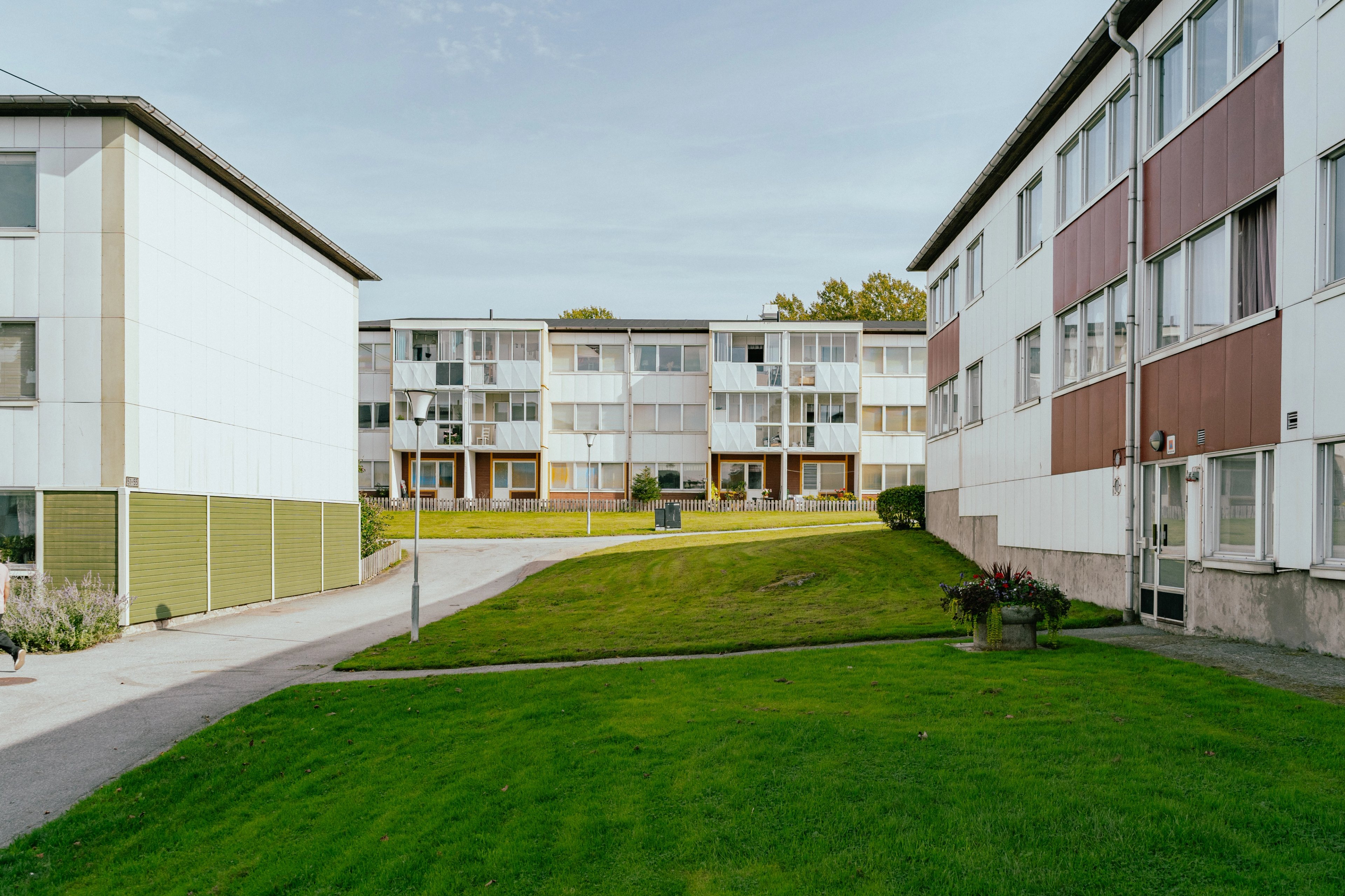 Stora gröna gräsmattor mellan hus-fasader