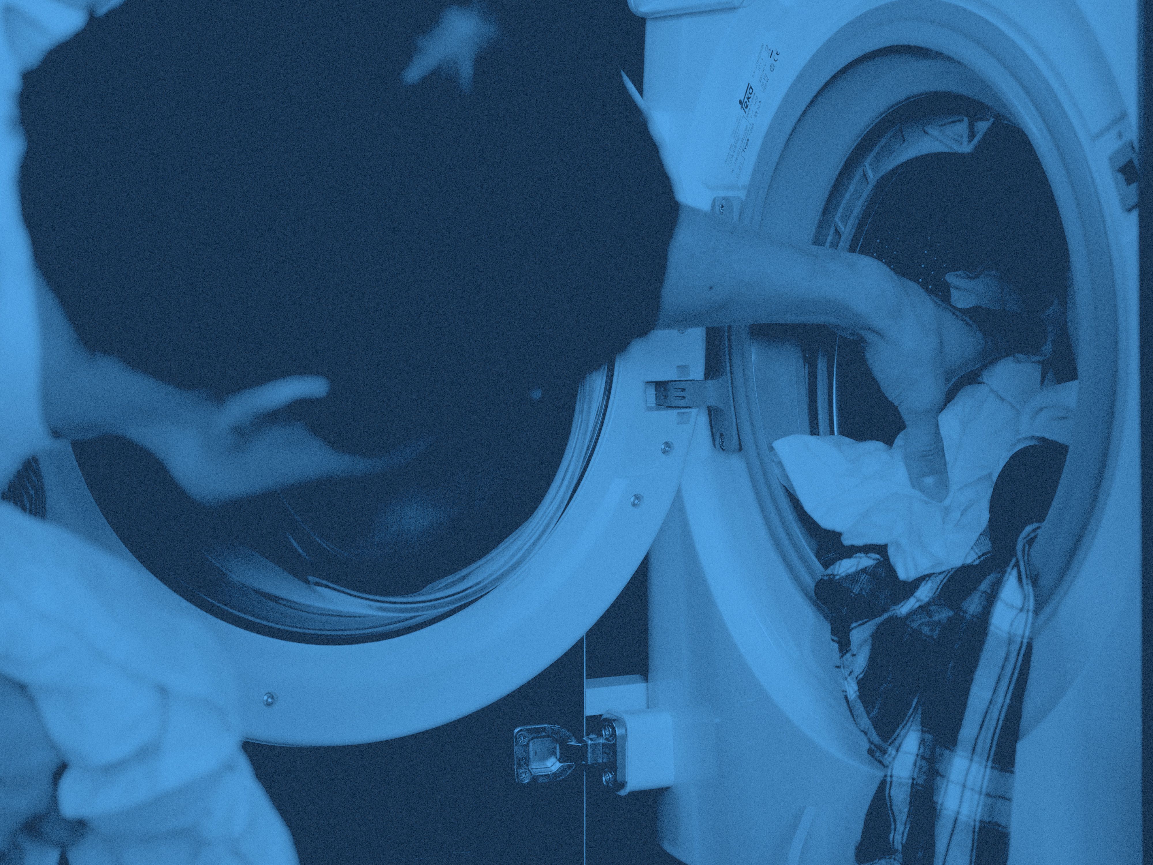 En man laddar en tvättmaskin