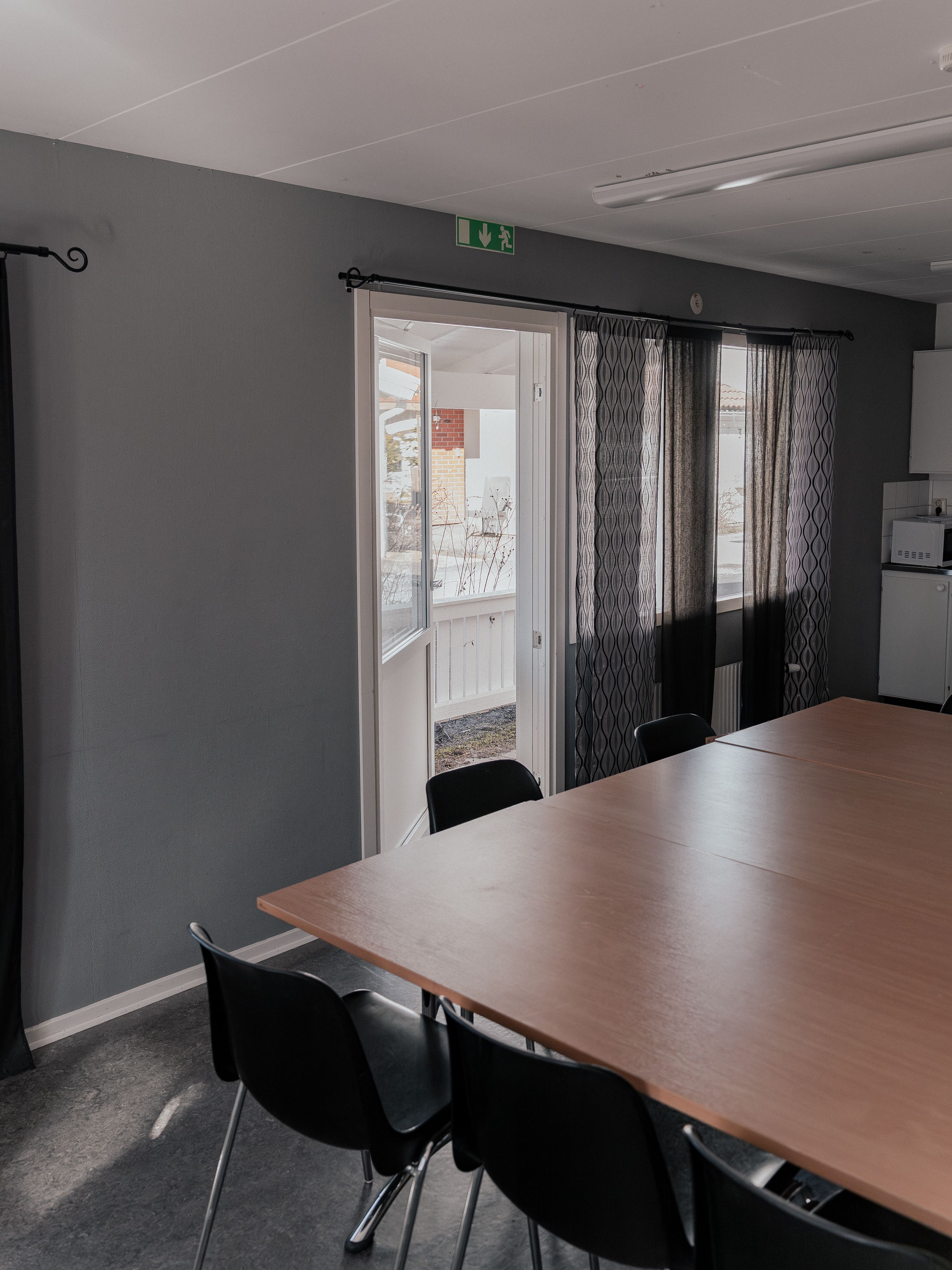 Ett konferensbord och en balkongdörr på glänt