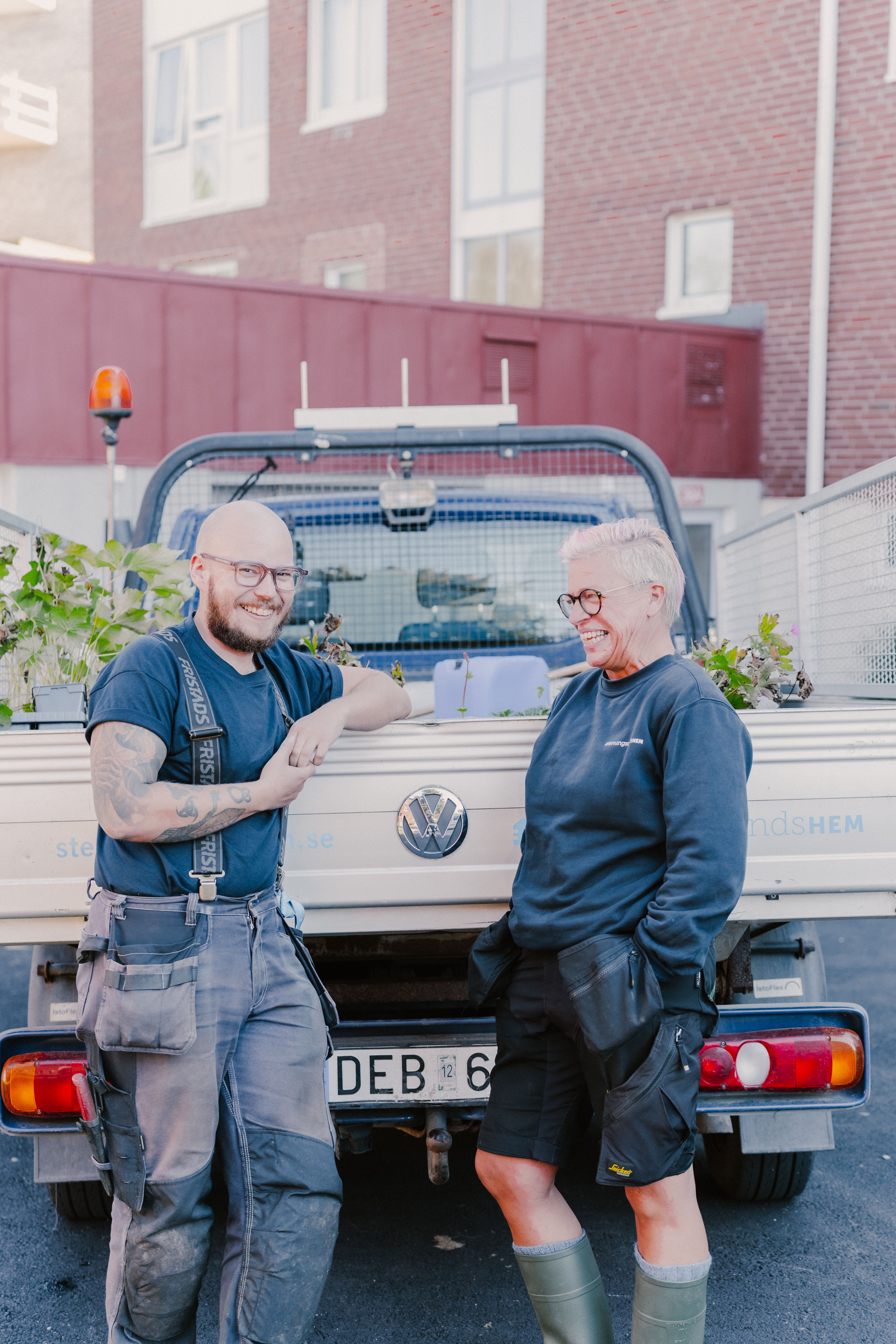 Två personer står bakom en lastbil