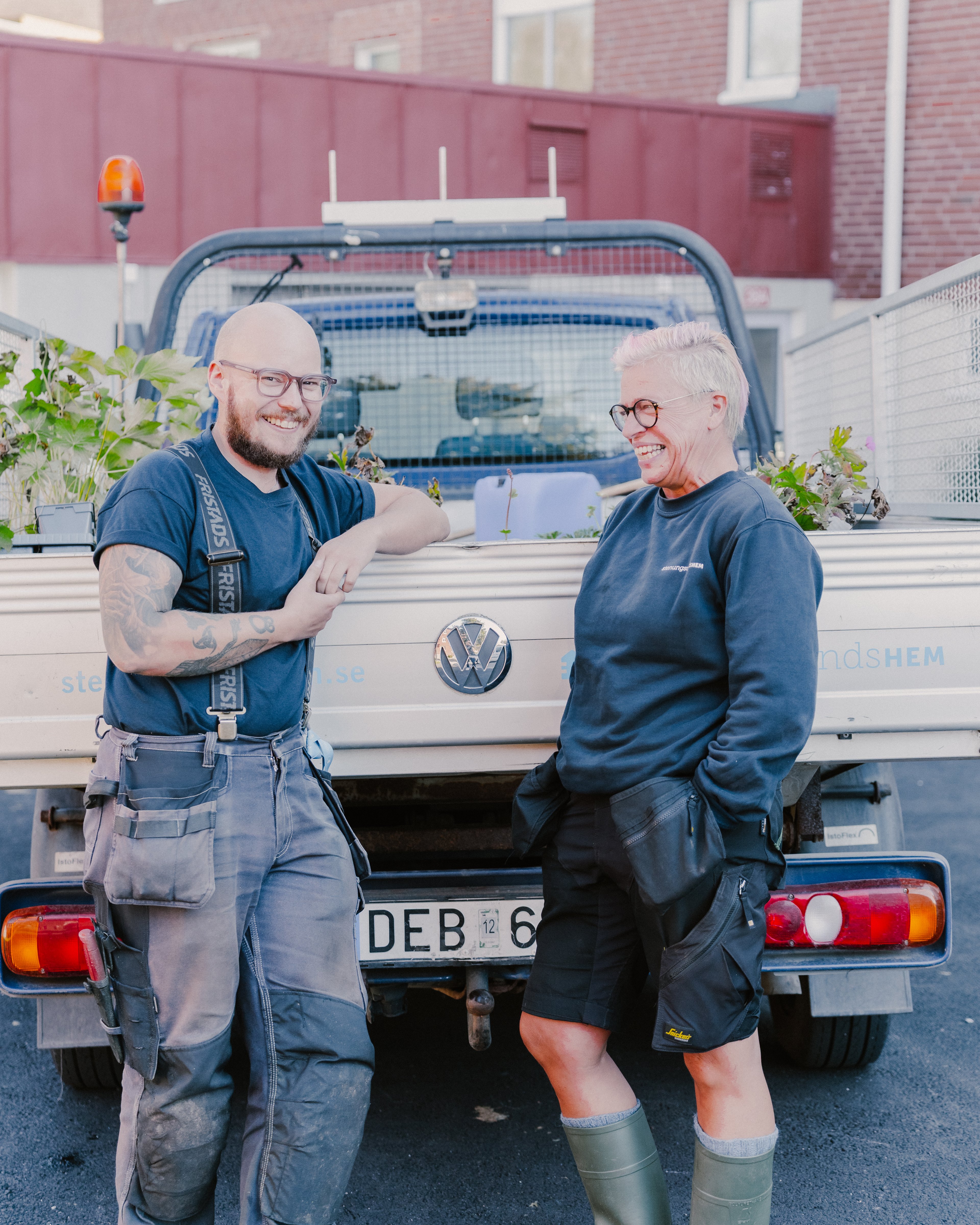 Två personer står bakom en lastbil