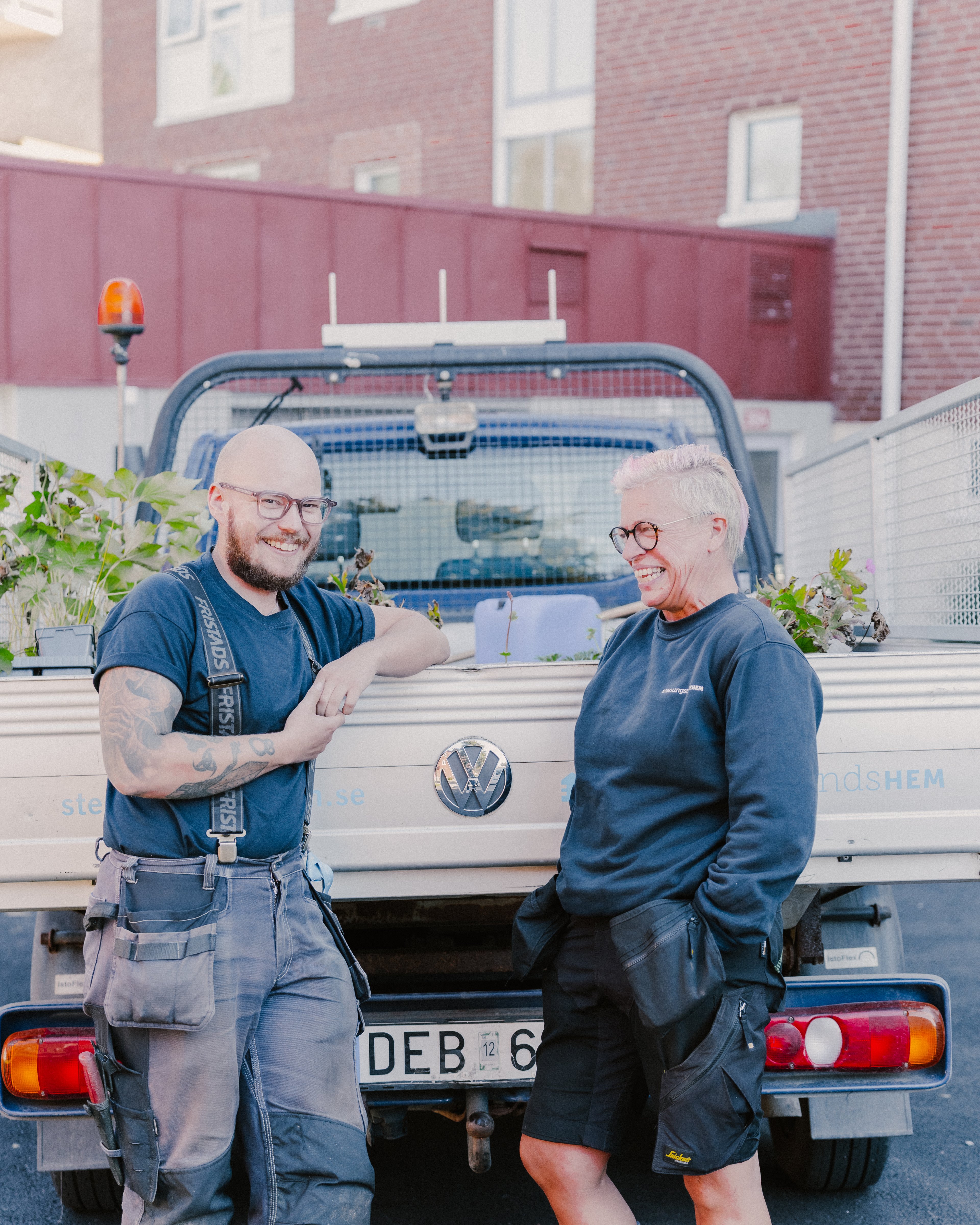 Två personer står bakom en lastbil