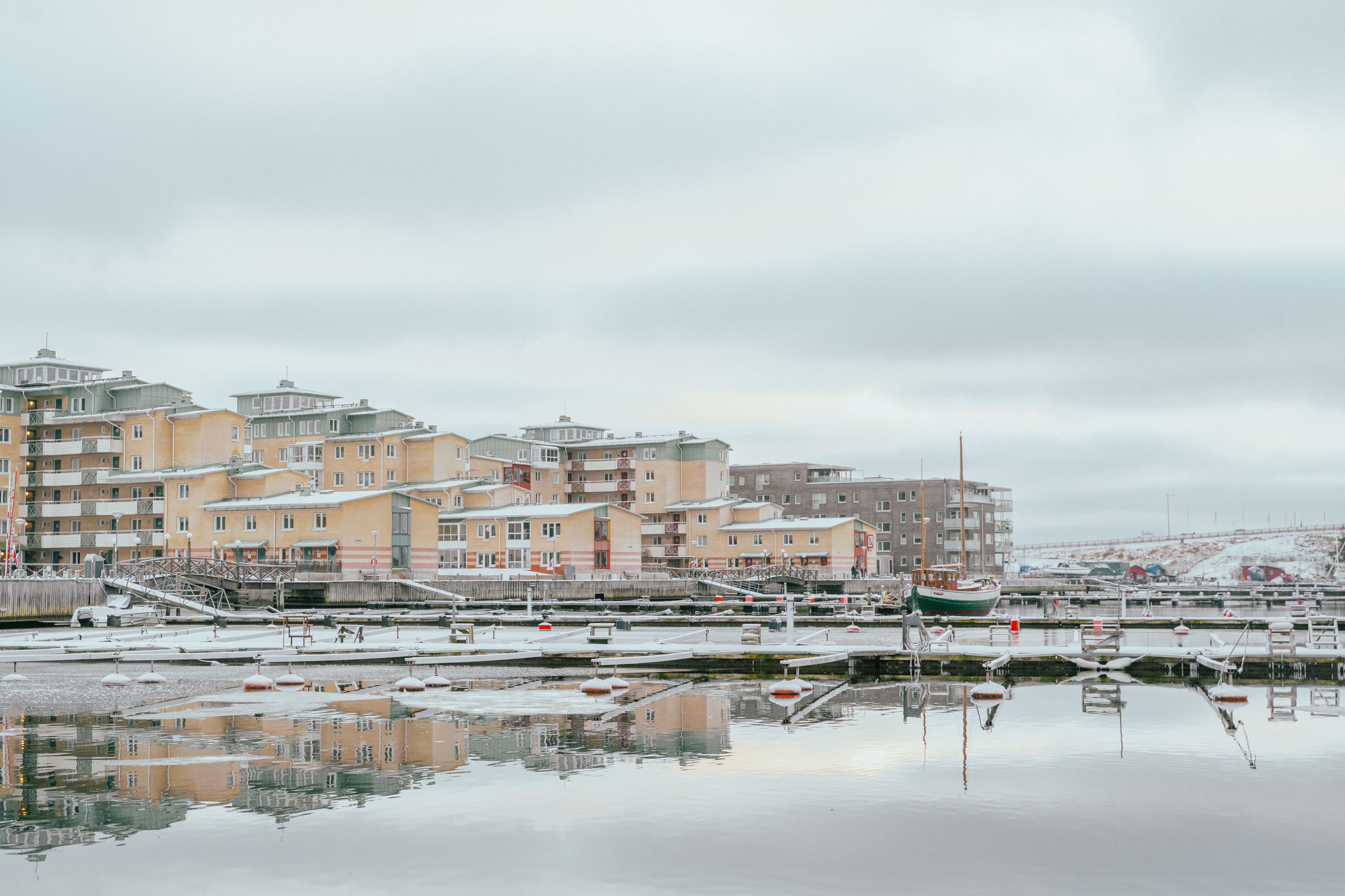 En tom småbåtshamn med hus i bakgrunden