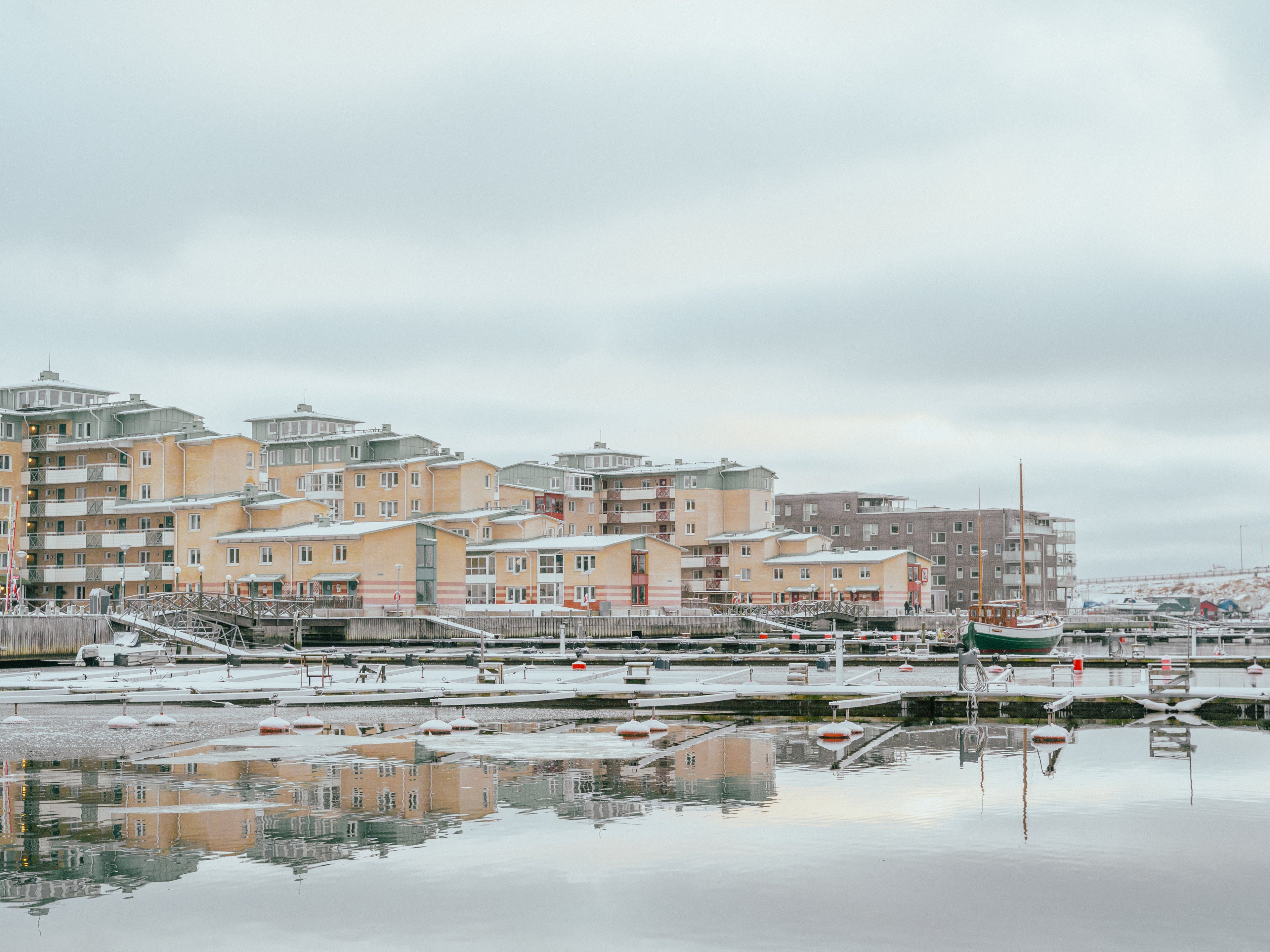 En tom småbåtshamn med hus i bakgrunden