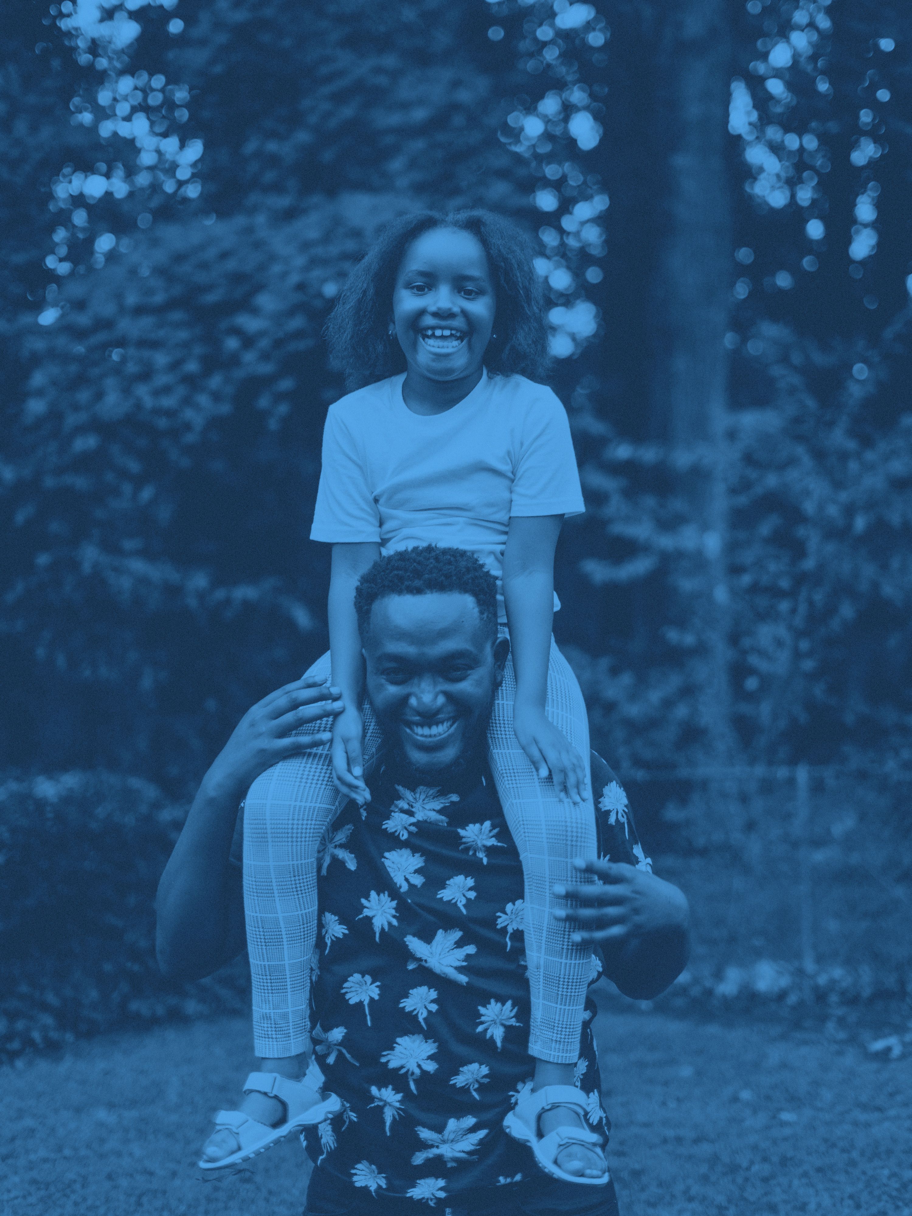 En pappa med en äldre dotter på axlarna