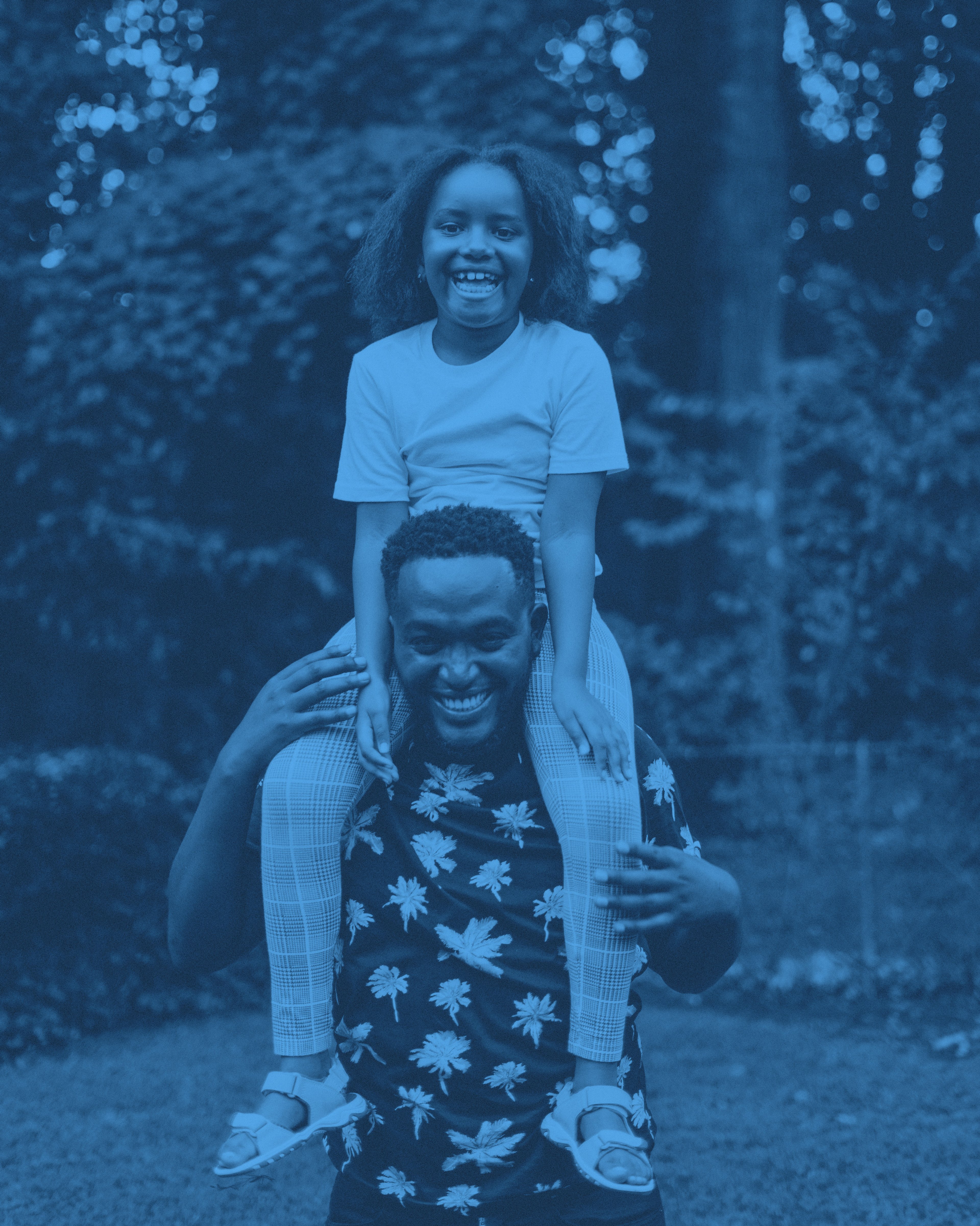 En pappa med en äldre dotter på axlarna