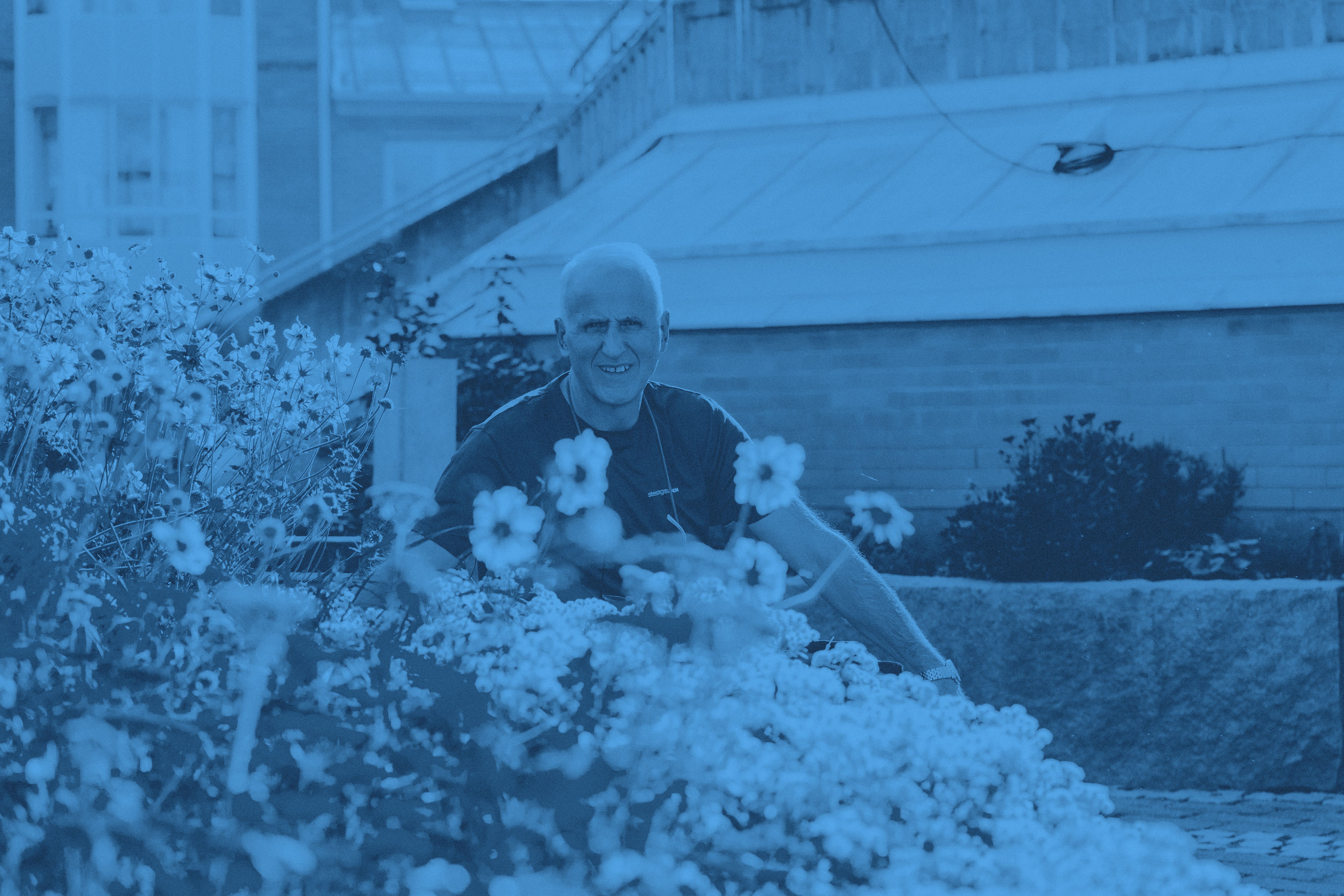 Vår medarbetare Bedri omgiven av blommor