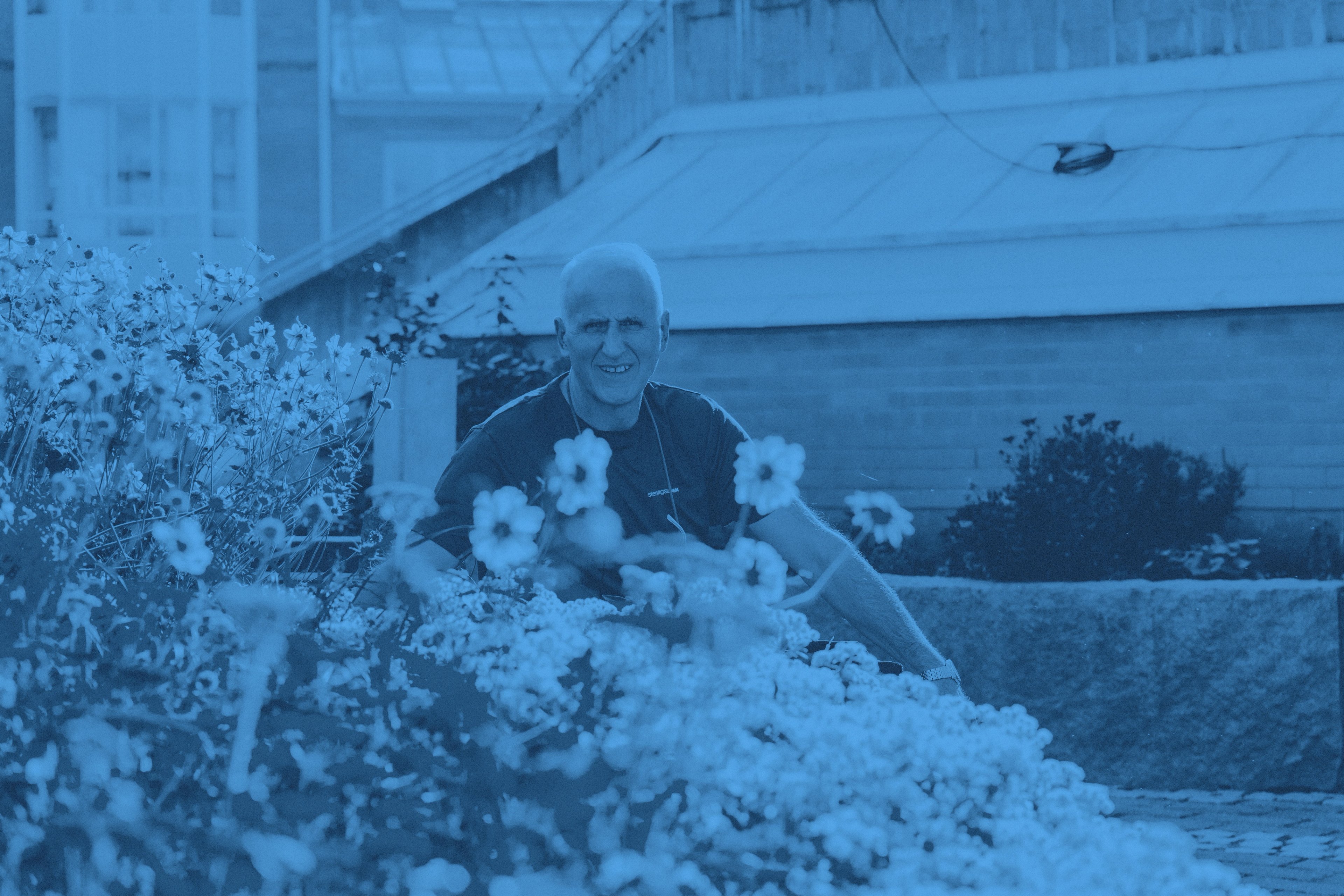 Vår medarbetare Bedri omgiven av blommor