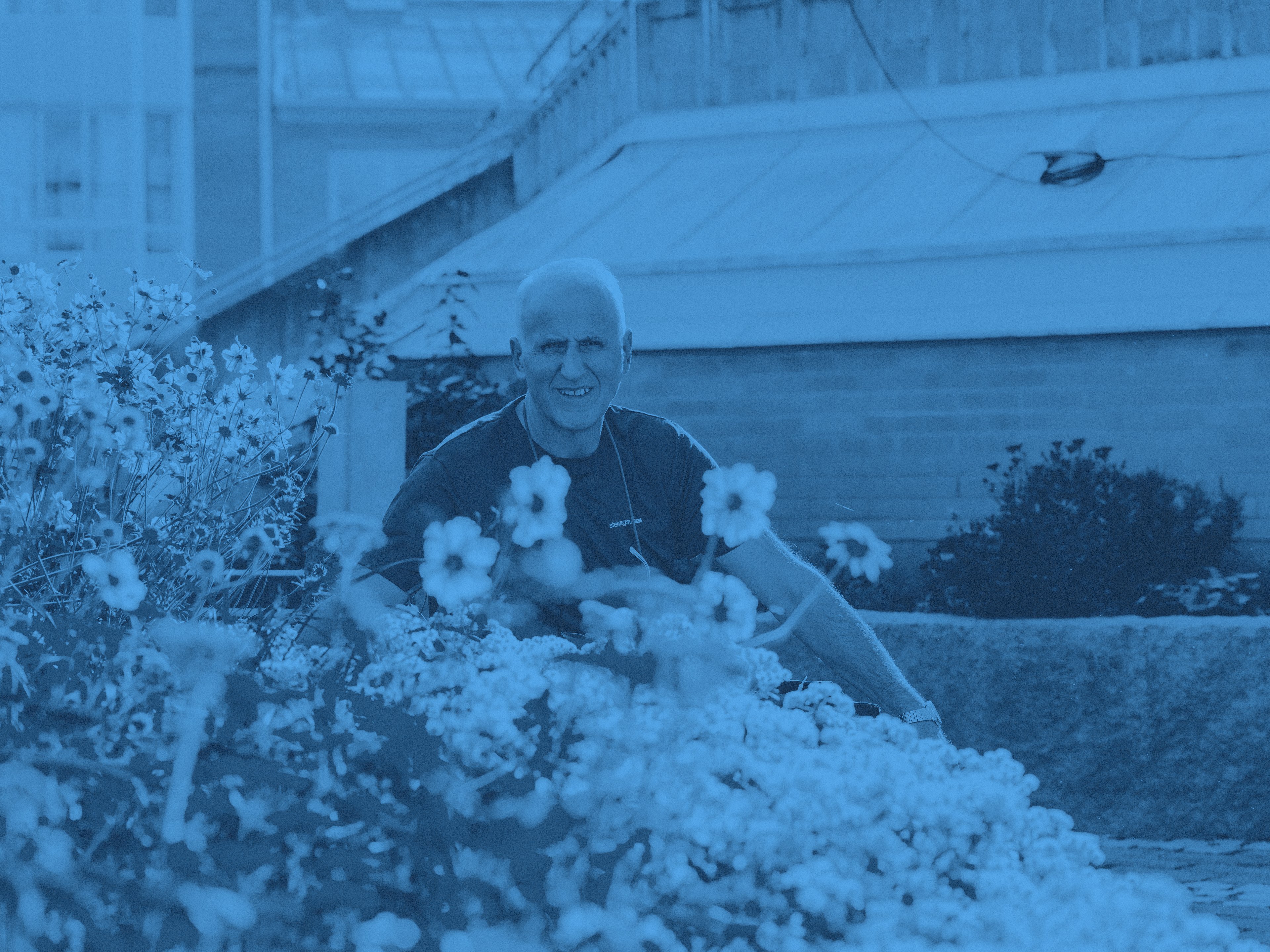Vår medarbetare Bedri omgiven av blommor