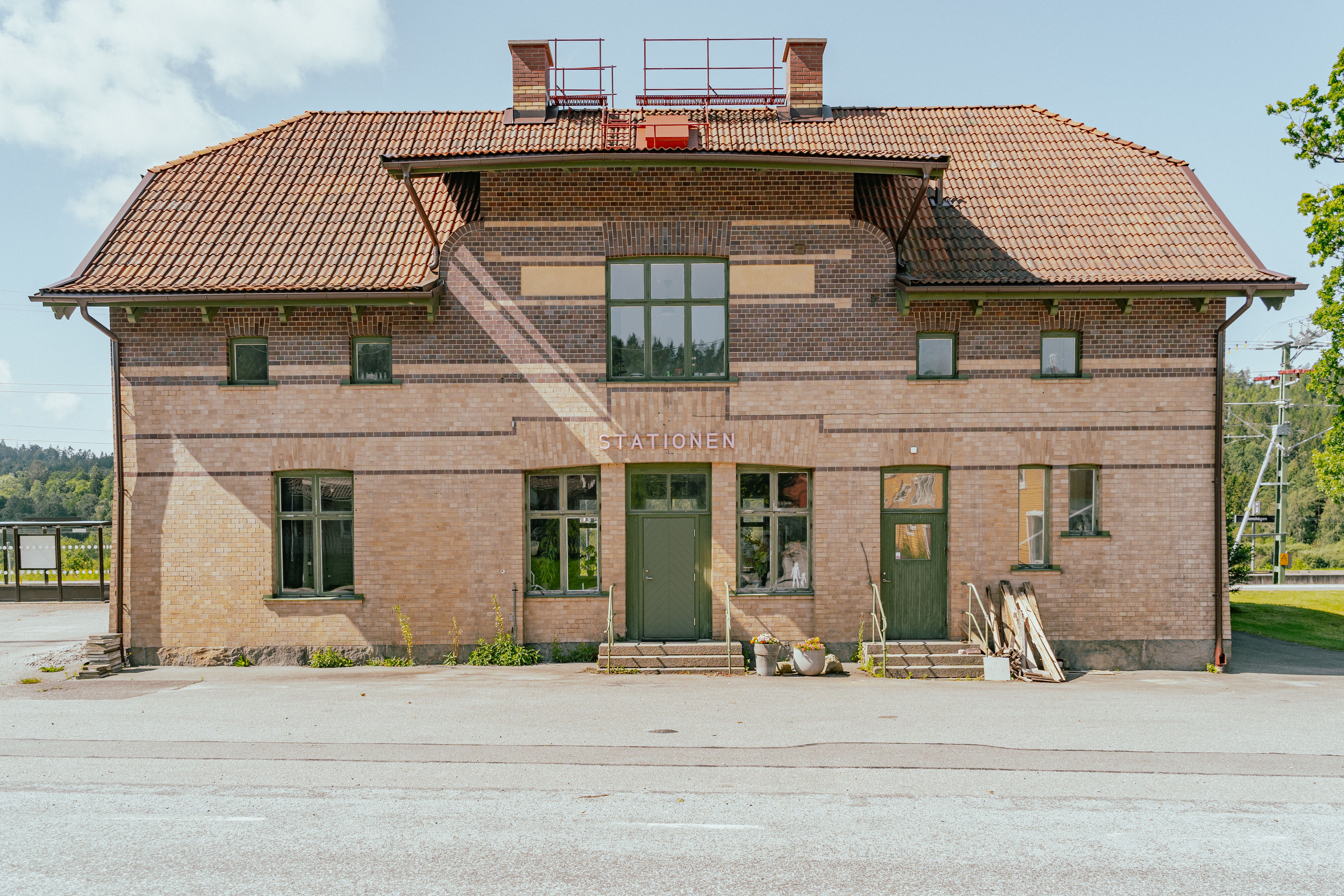 Ett gammalt hus i tegel med en skylt där det står stationen